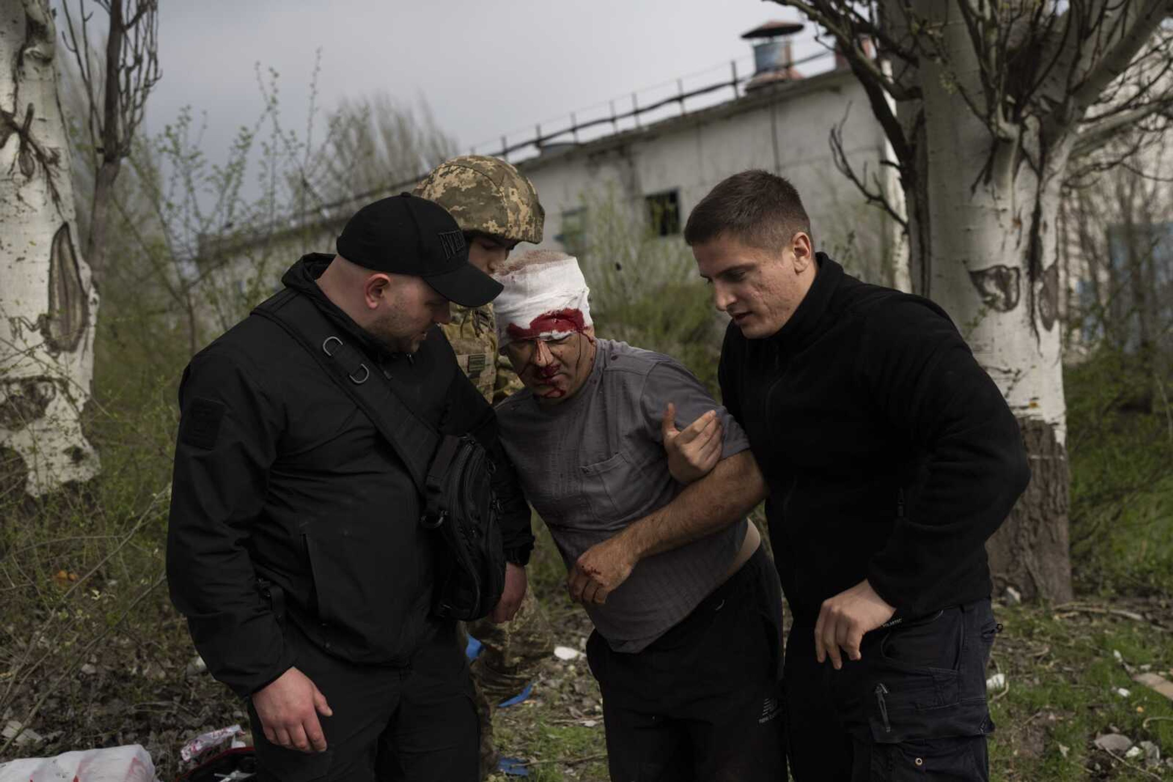 Members of security forces help an injured man after a Russian bombing of a factory Tuesday in Kramatorsk, eastern Ukraine, which killed at least one person and injured three others. Russian forces attacked along a broad front in eastern Ukraine on Tuesday as part of a full-scale ground offensive to take control of the country's eastern industrial heartland in what Ukrainian officials called a "new phase of the war."