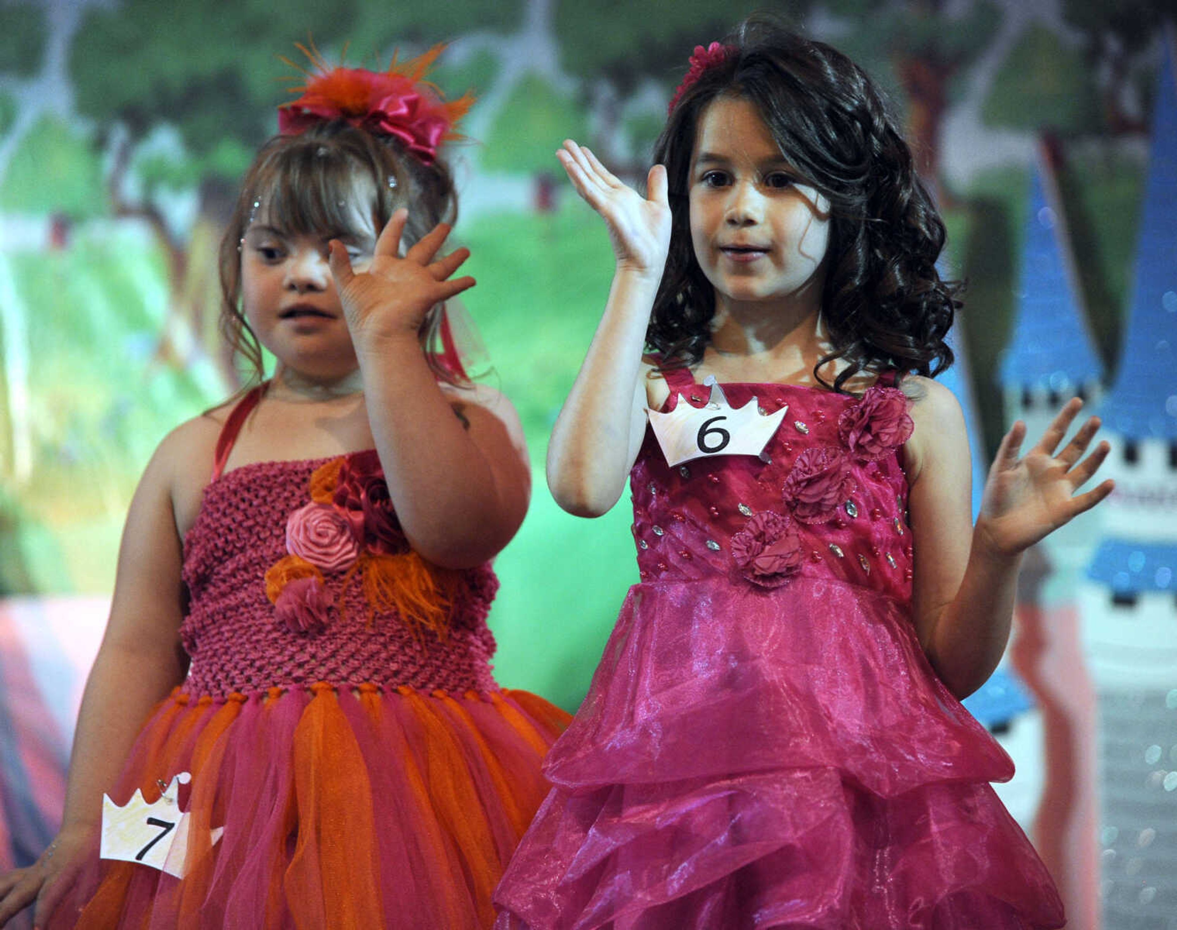 Emily Crider, left, and Phoenix Chicora wave to the crowd in the 5-9 age division of the S. E. Missouri Angels Pageant on Saturday, April 26, 2014 at Scott City High School.