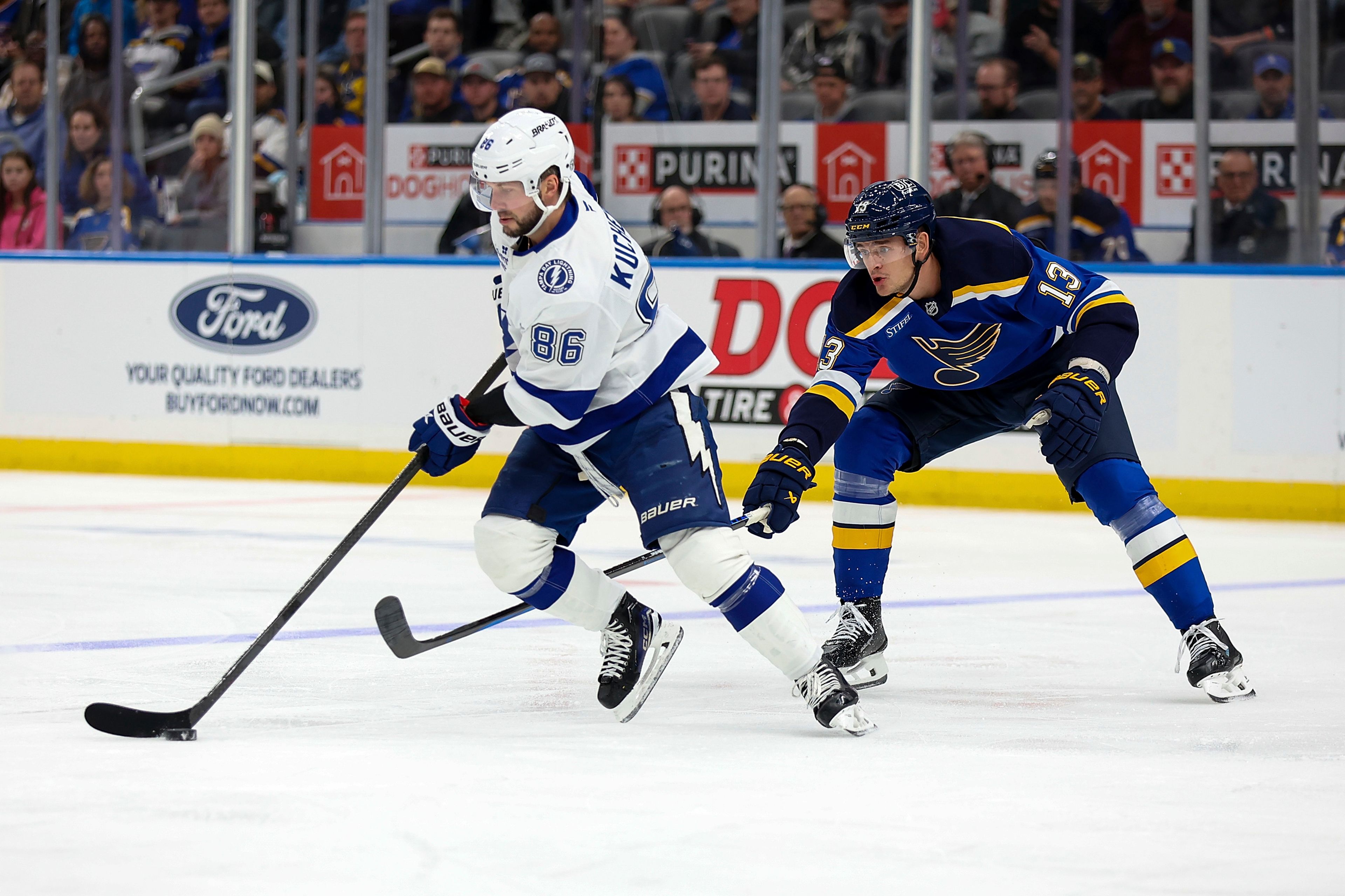 Tampa Bay Lightning's Nikita Kucherov (86) controls the puck while under pressure from St. Louis Blues' Alexey Toropchenko (13) during the first period of an NHL hockey game Tuesday, Nov. 5, 2024, in St. Louis. (AP Photo/Scott Kane)