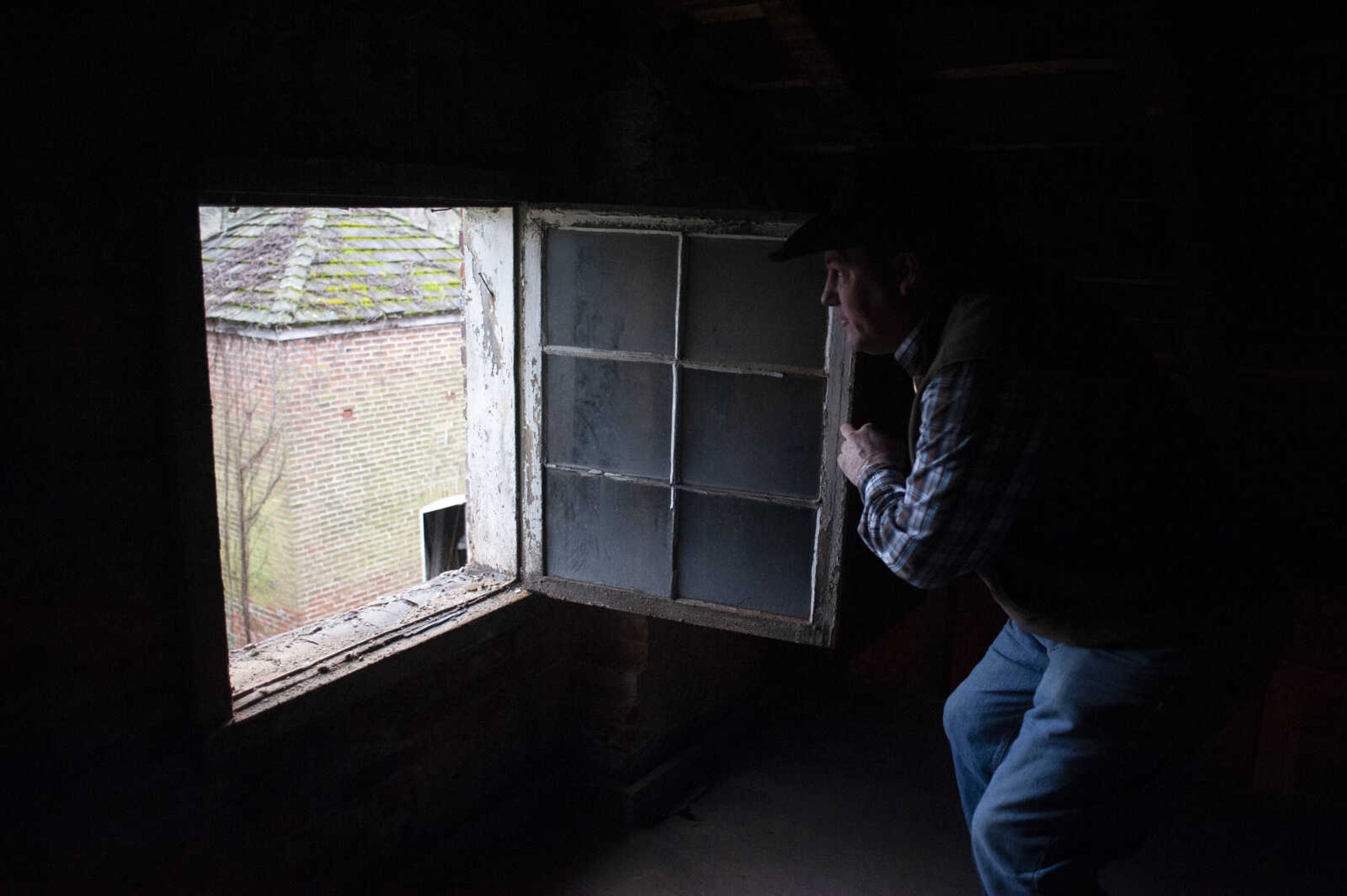 Contractor Brock Milam of Benton, Missouri, looks out an upstairs' window while showing some of the area under rehabilitation at the Reynolds House on Wednesday, Jan. 23, 2019, at 623 N. Main St. in Cape Girardeau.