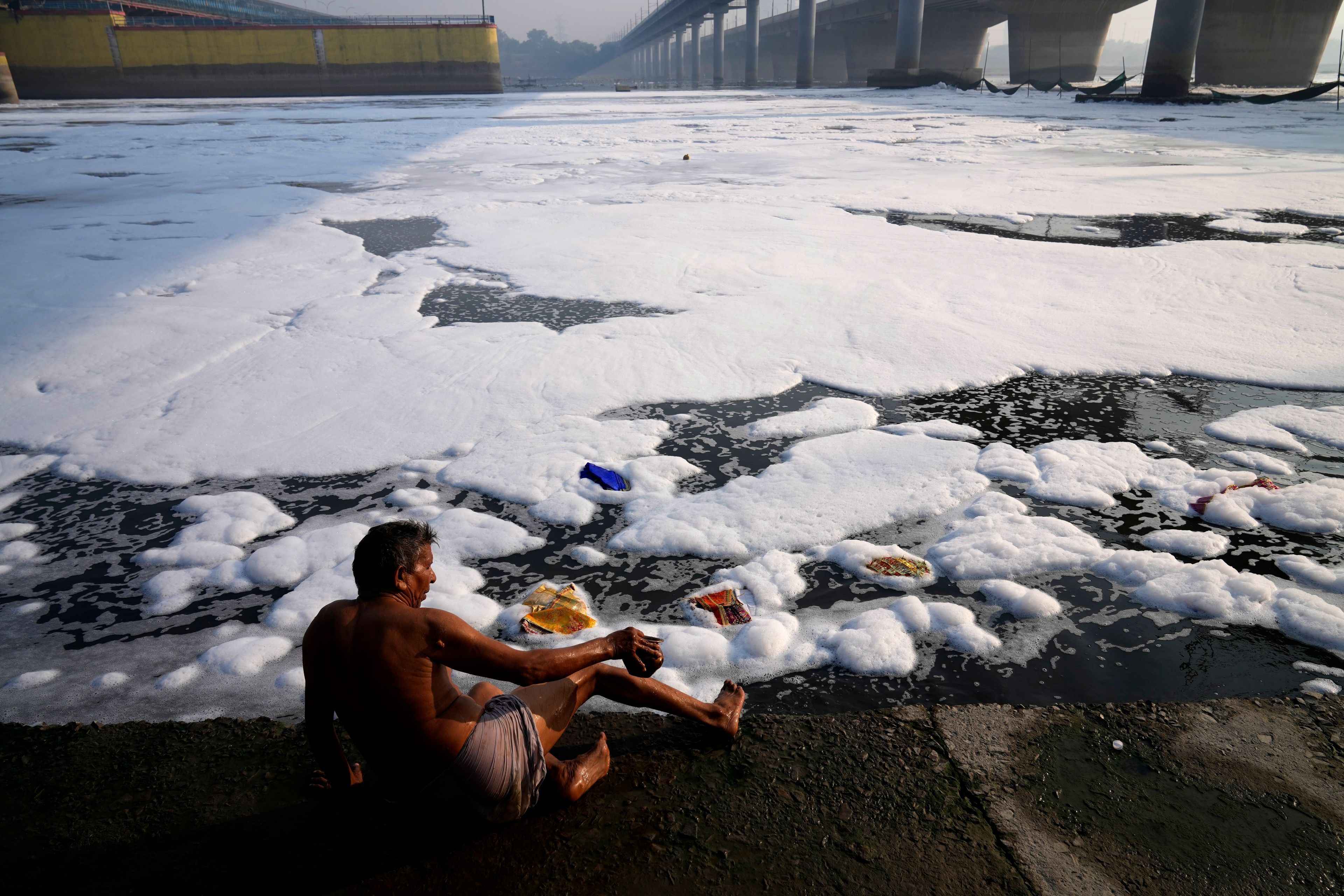 Jasraj, 70, takes bath on the banks of the the river Yamuna filled with toxic foams in New Delhi, India, Tuesday, Oct. 29, 2024. (AP Photo/Manish Swarup)