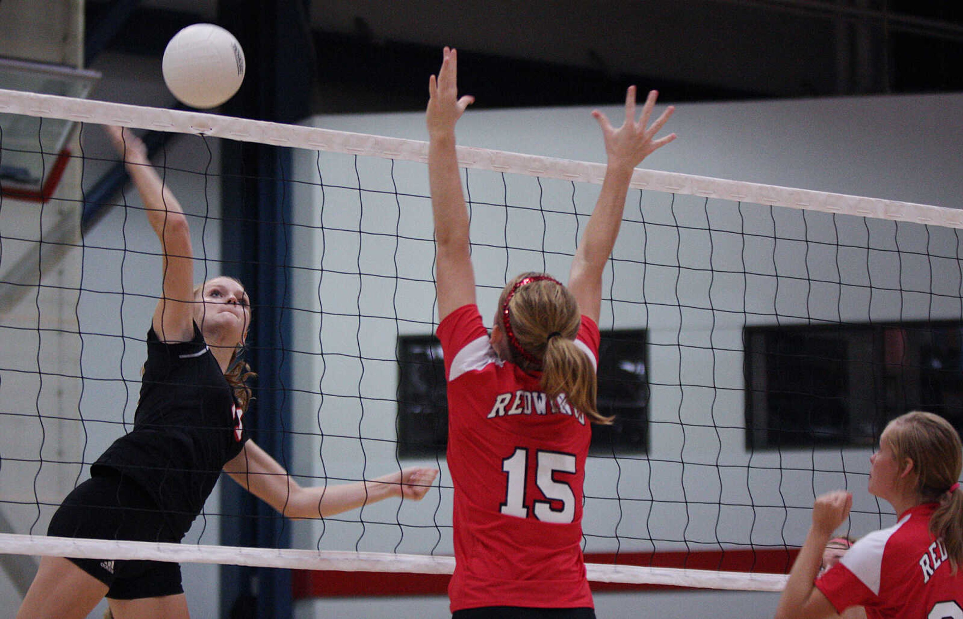 Jackson's MaryAnn Bradshaw, left, spikes the ball against Eminence.