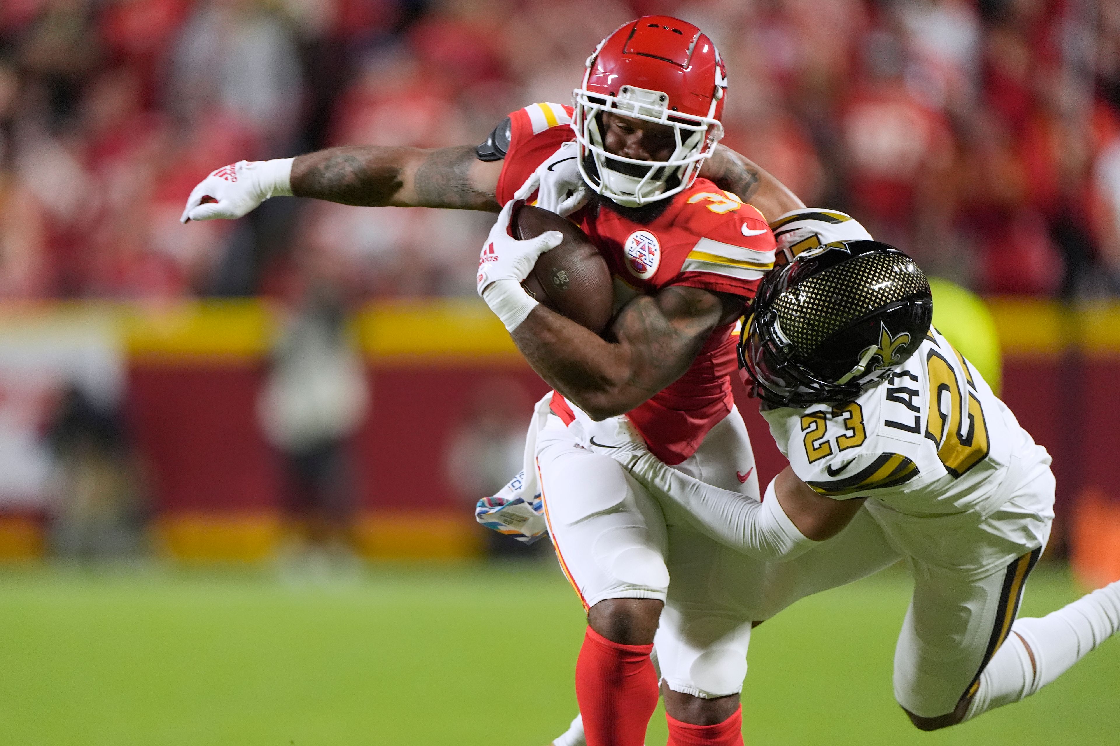 Kansas City Chiefs running back Samaje Perine, left, is stopped by New Orleans Saints cornerback Marshon Lattimore (23) during the first half of an NFL football game Monday, Oct. 7, 2024, in Kansas City, Mo. (AP Photo/Charlie Riedel)