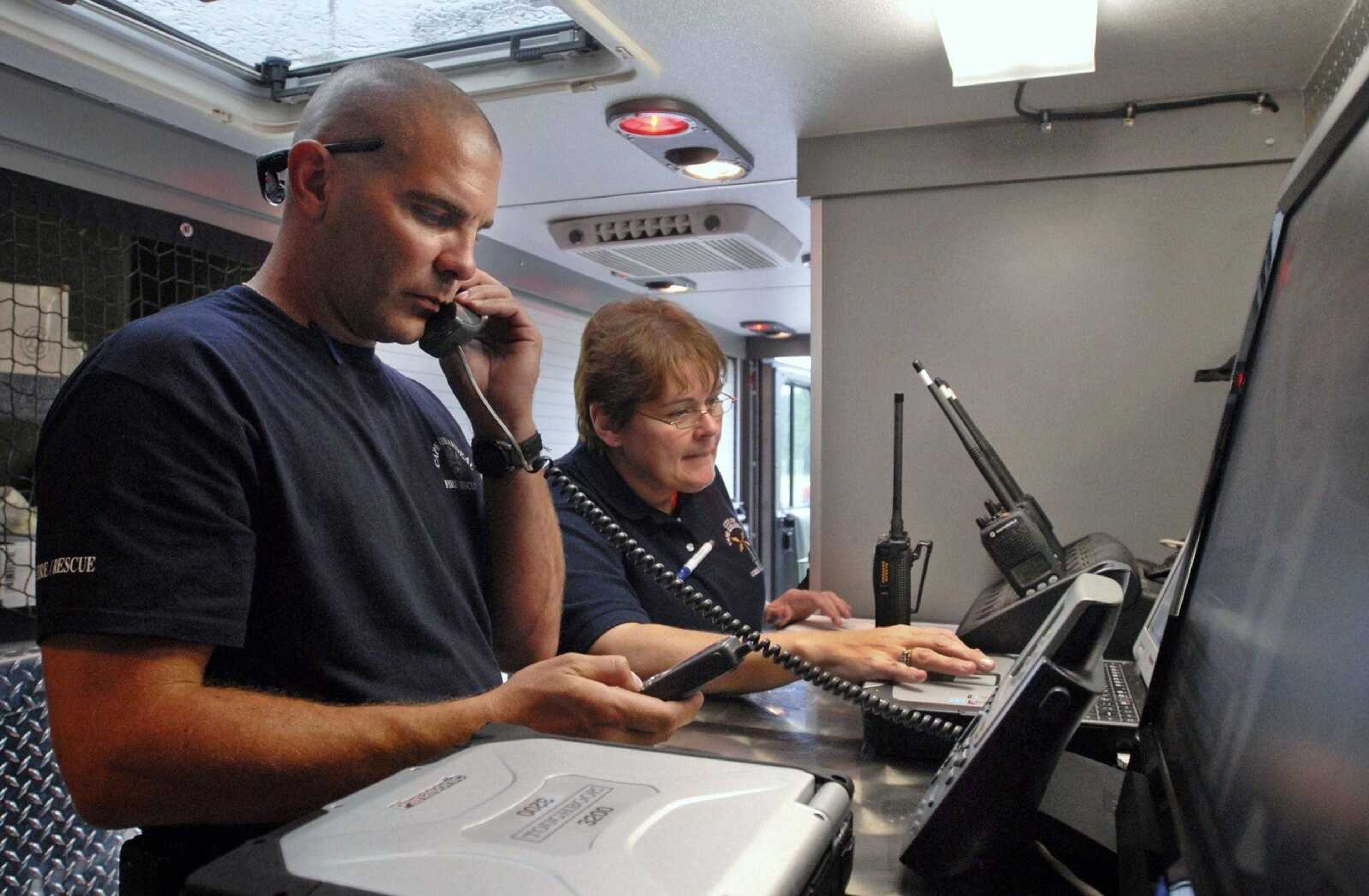 Battalion Chief Brad Dillow, of Cape Girardeau Fire and Rescue, and Debbie Maupin, of 911 Communications, participate in communications training outside the Osage Center in Cape Girardeau on Thursday, Sept. 9, 2010. Area first responders worked with the Missouri National Guard's Seventh Civil Support Team to practice communication techniques, including fax, email, video streaming, still image transfer, and phone access through land-line, satellite, and Internet, during a simulated remote emergency situation. Training will continue on Friday with simulated Hazmat response exercises near Sloan Creek in Cape Girardeau. (Kristin Eberts)