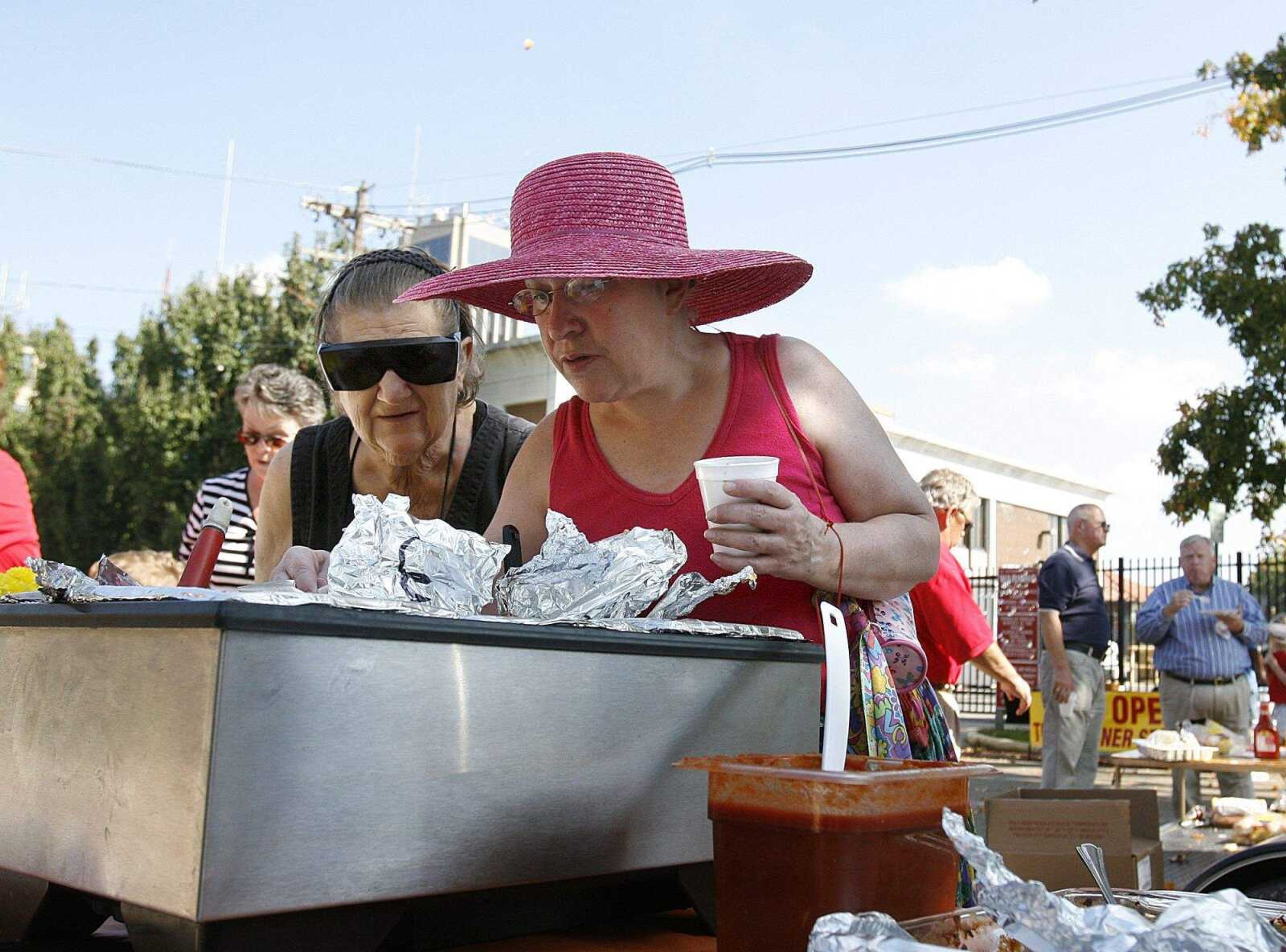 ELIZABETH DODD ~ edodd@semissourian.com
Holly Little, left, and Linda Royce, both of Cape Girardeau investigate the wide variety of food options at the Neighborhood Connections Block Party on Fountain Street in Cape Girardeau Saturday.