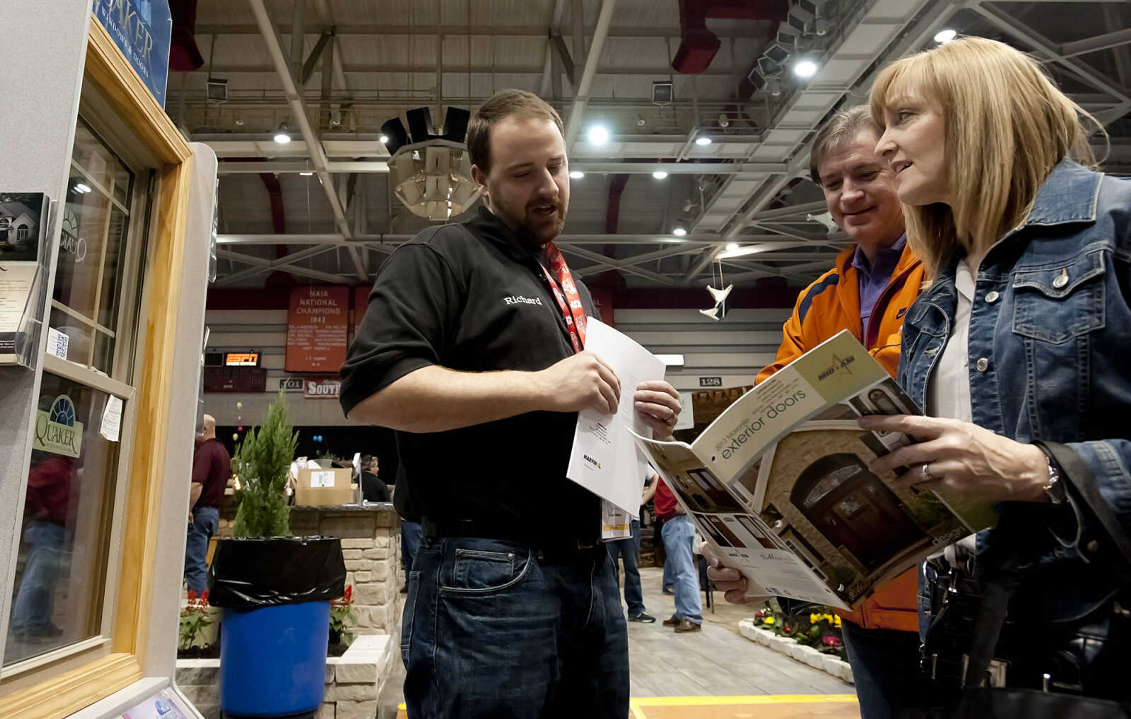 Jackson Glass's Richard Jenkins, left, talks with Gary and Lisa Helle of Cape Girardeau at the Tri State Regional Home and Garden Show at the Show Me Center. The show featured more than 100 exhibits. (Adam Vogler)