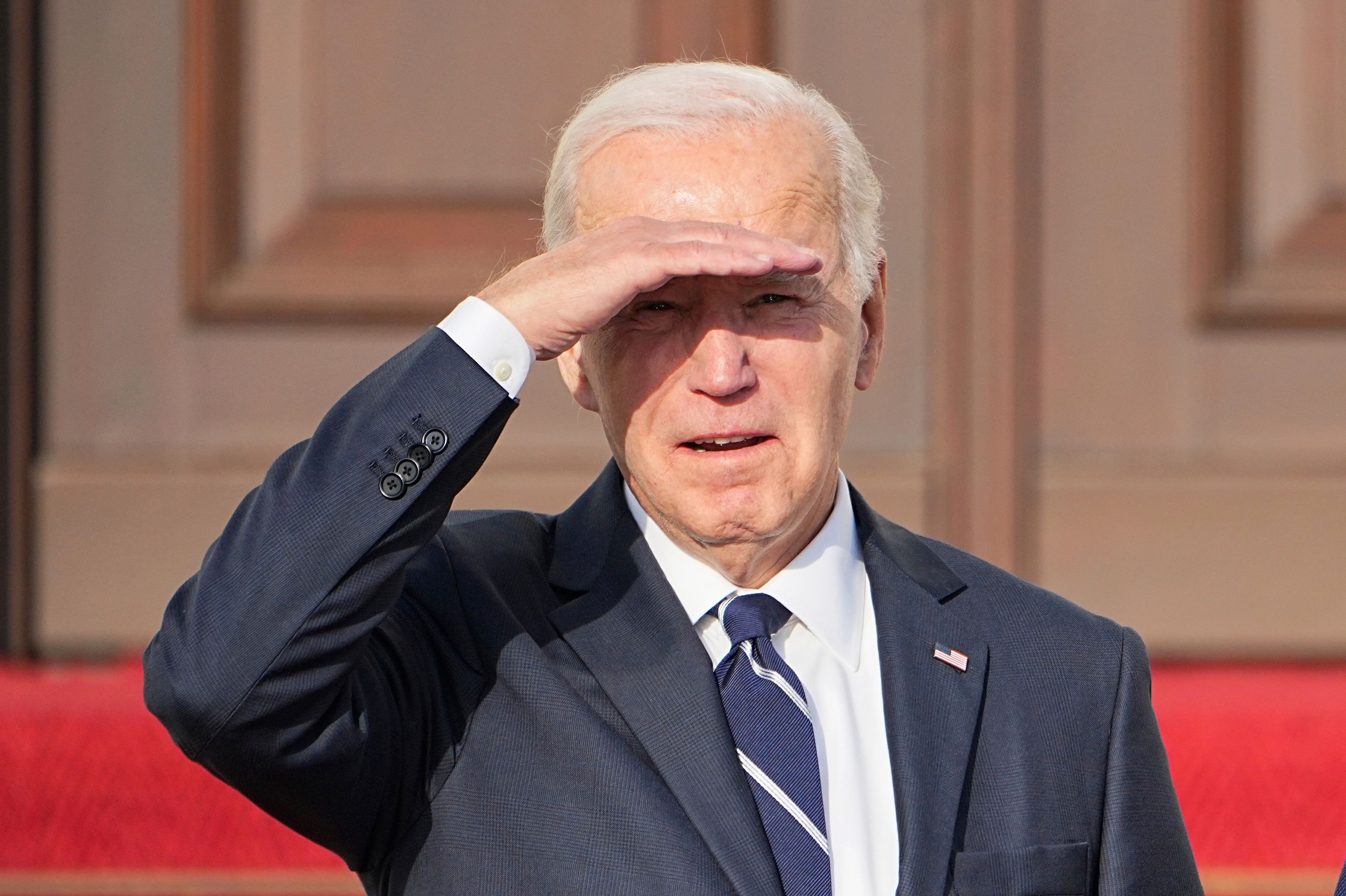 U.S. President Joe Biden covers himself from the sun as he arrives at Bellevue Palace during his first bilateral visit to Germany, in Berlin, Friday Oct. 18, 2024. (Michael Kappeler/dpa via AP)