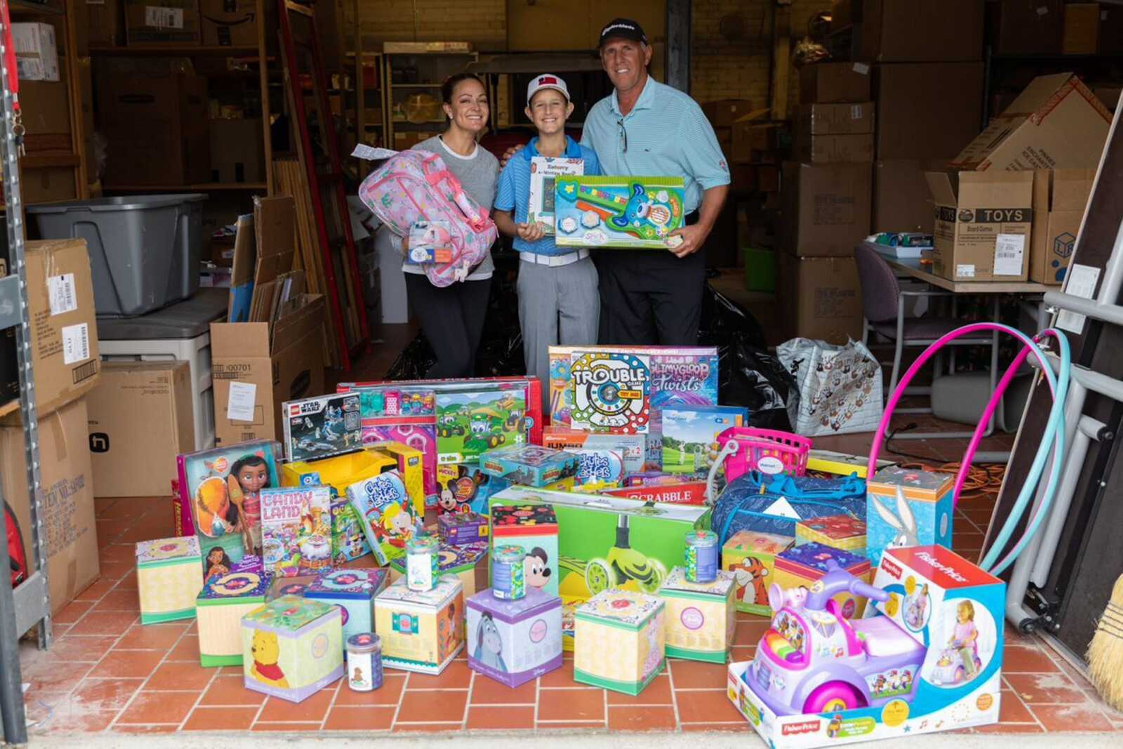 Jimmy Williams (center) and his parents Shana Williams (left) and father Jim Williams pose with toys Jimmy donated to Cardinal Glennon Children's Hospital in St. Louis.