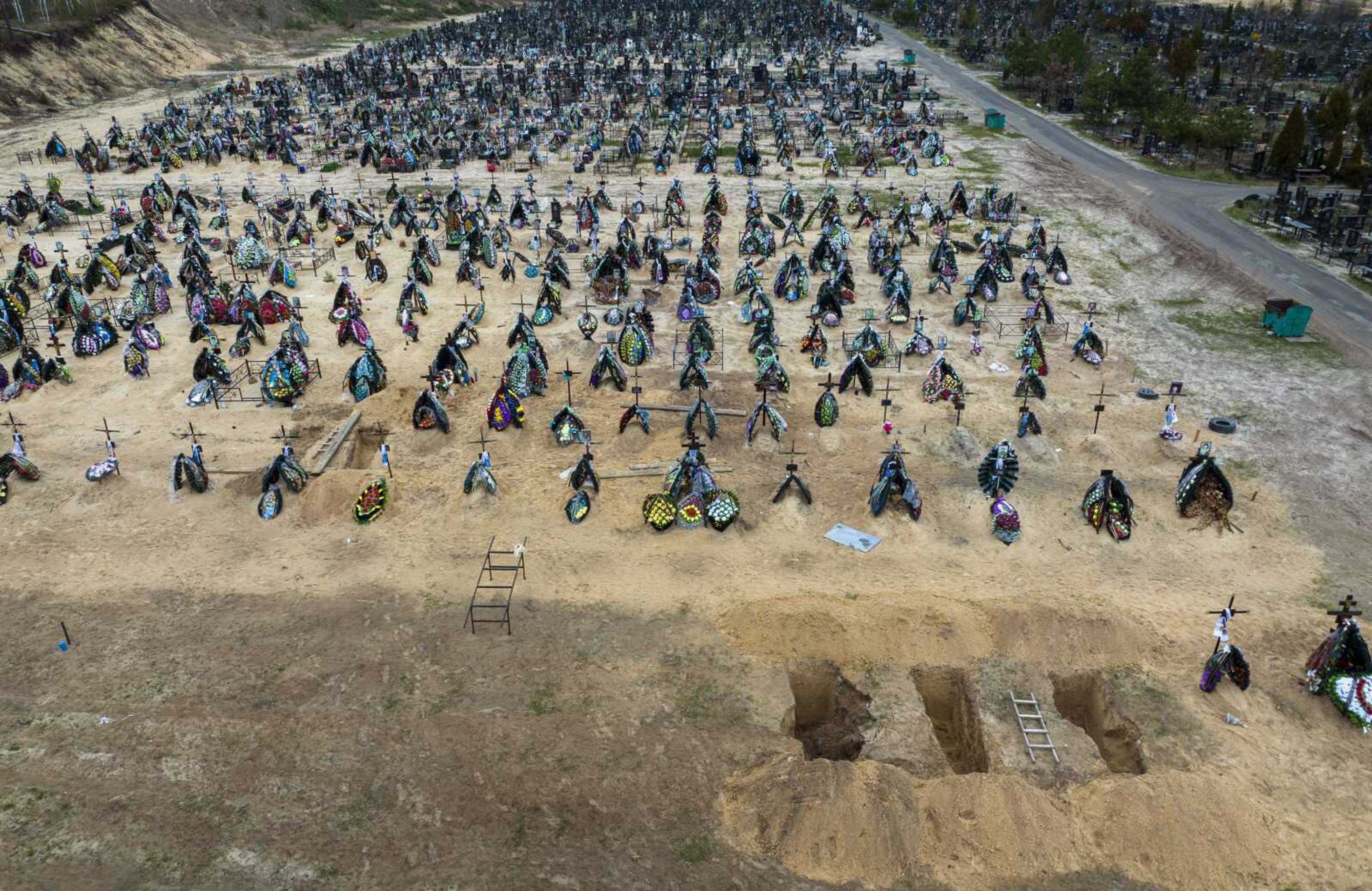 A general view of the cemetery in Irpin where three dug graves await the next funerals Tuesday in the outskirts of Kyiv, Ukraine.