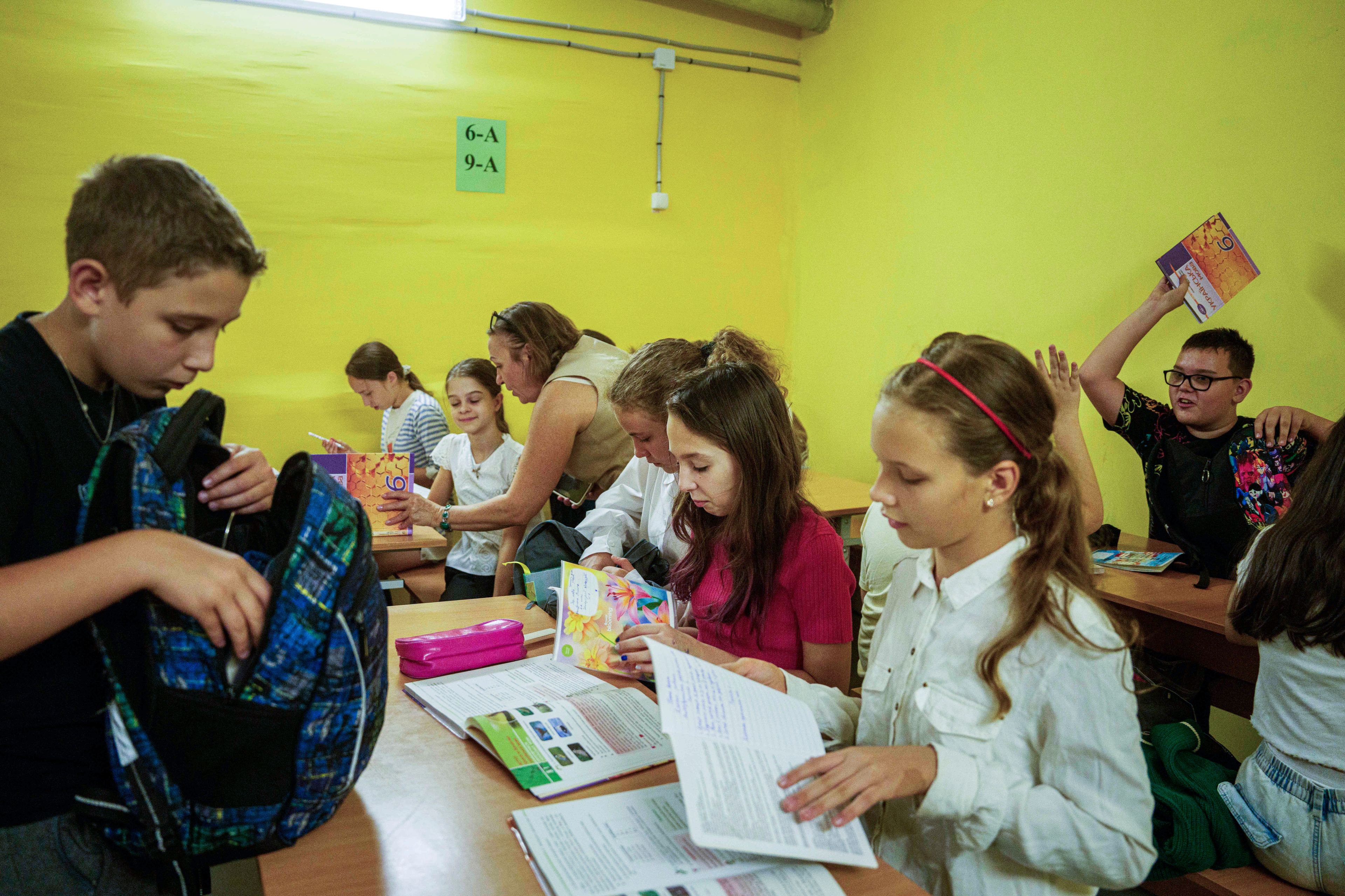 Children from Gymnasium No. 6 spread out their books in a school basement during an air alert in Zaporizhzhia, Ukraine, Sept. 3, 2024. (AP Photo/Evgeniy Maloletka)