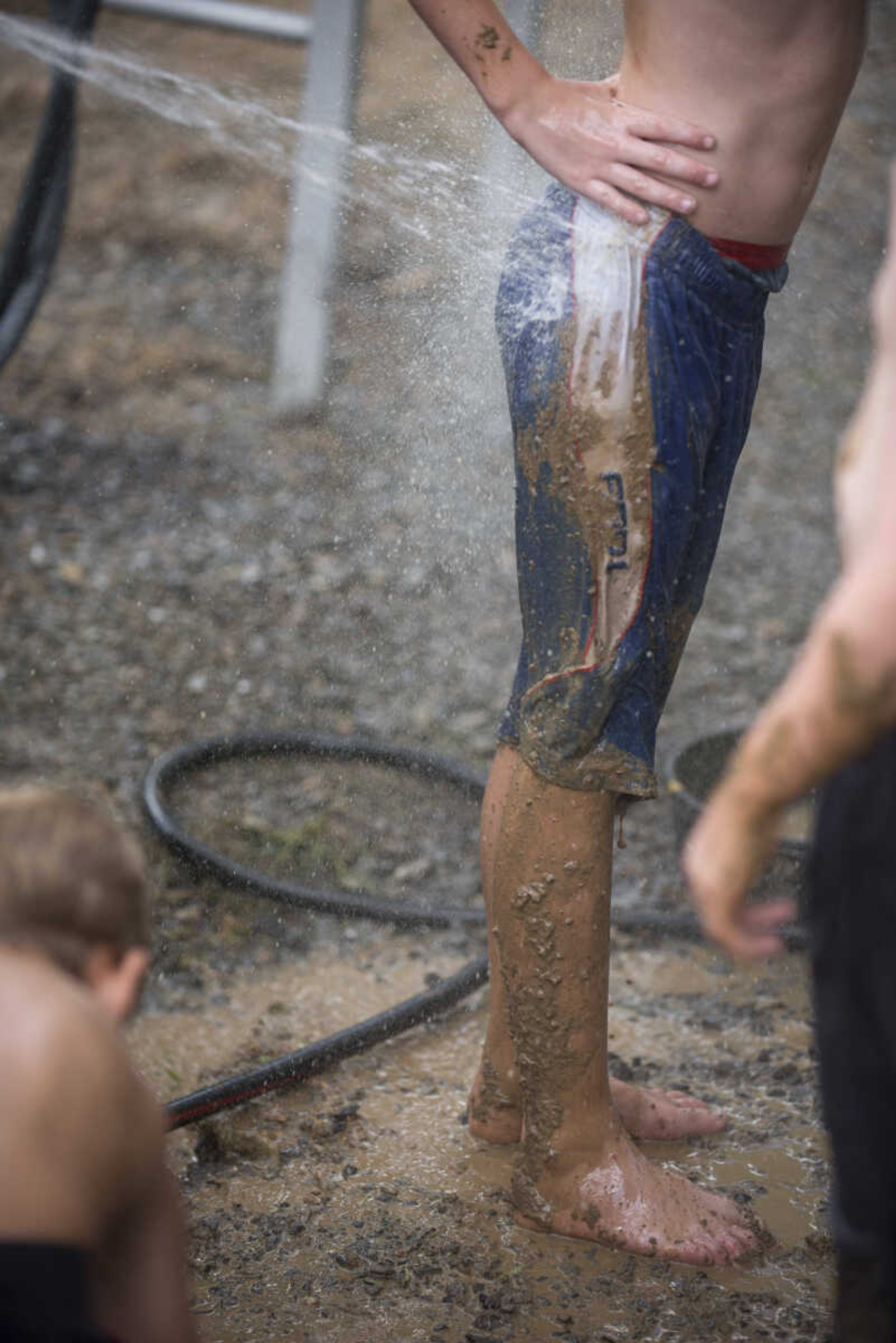 Contestants get hosed off after the kiddie mud races during Benton Neighbor Days Saturday, September 1, 2018.