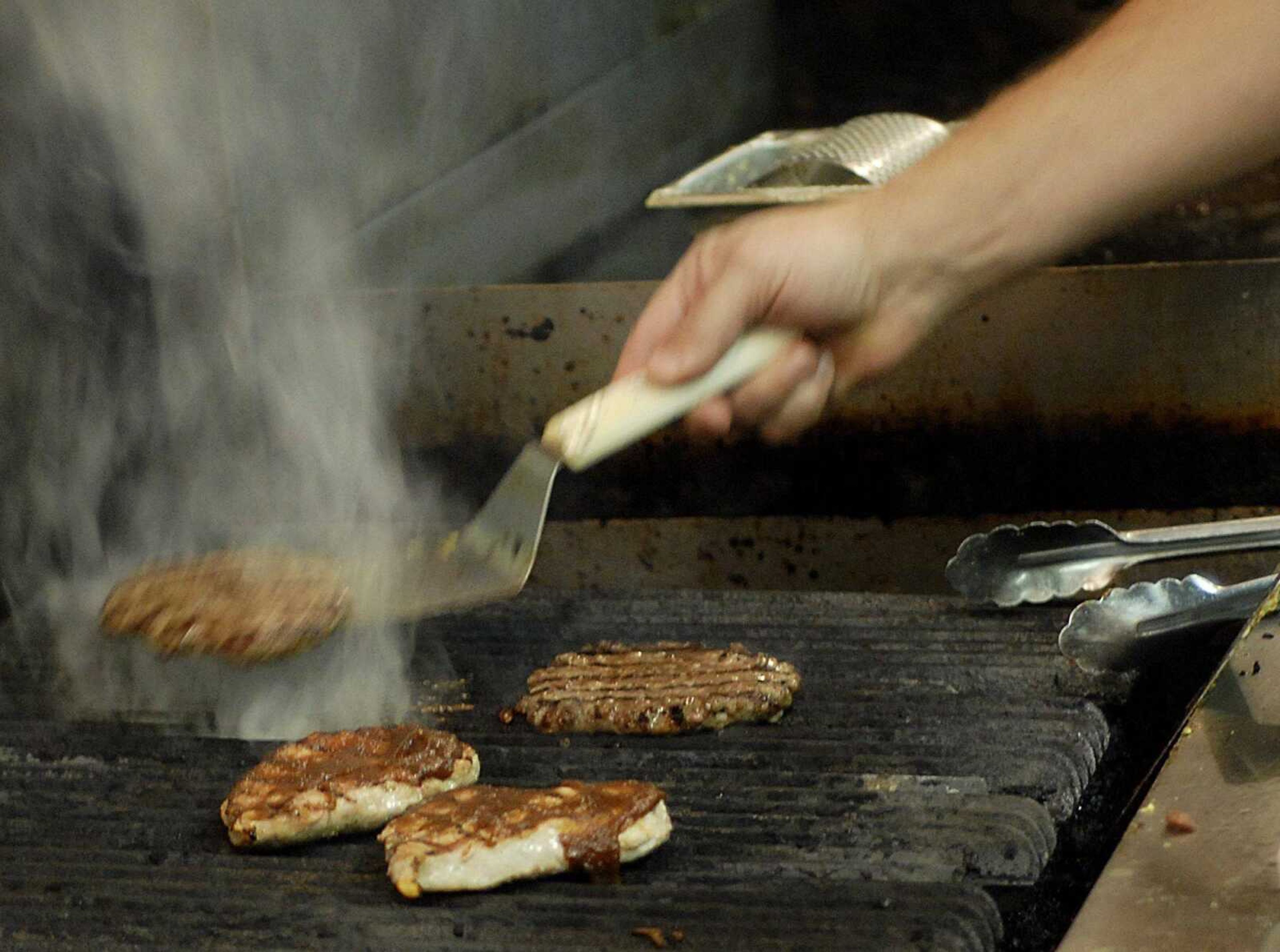 Burgers and pork chops are cooked on the grill at Jimmie's on Tuesday, December 11, 2007. (Aaron Eisenhauer)