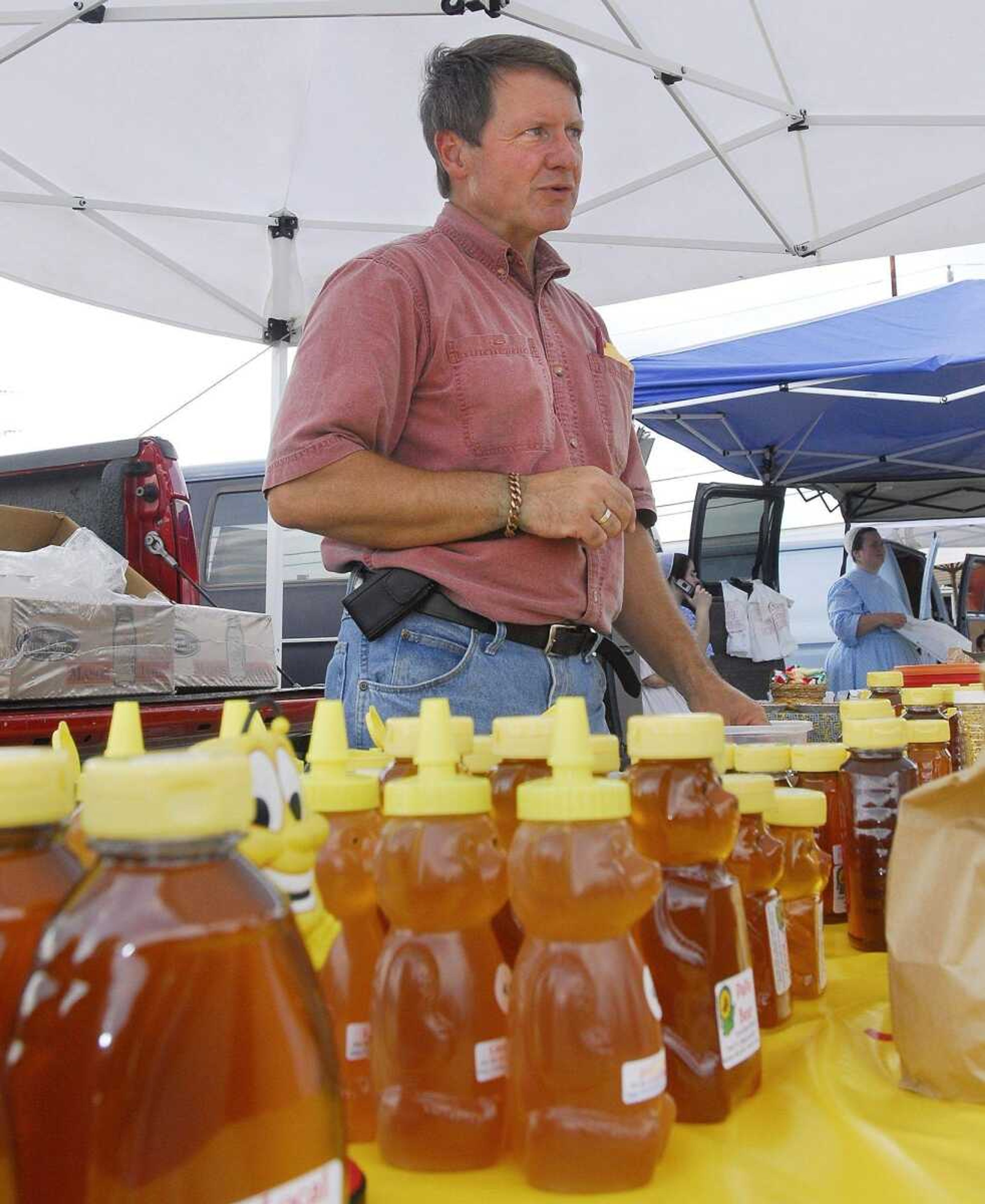 Rev. Grant F.C. Gillard of Jackson stands behind his naturally produced honey at his stand Thursday, June 10, 2010 at the Cape Girardeau farmer's market. (Laura Simon)