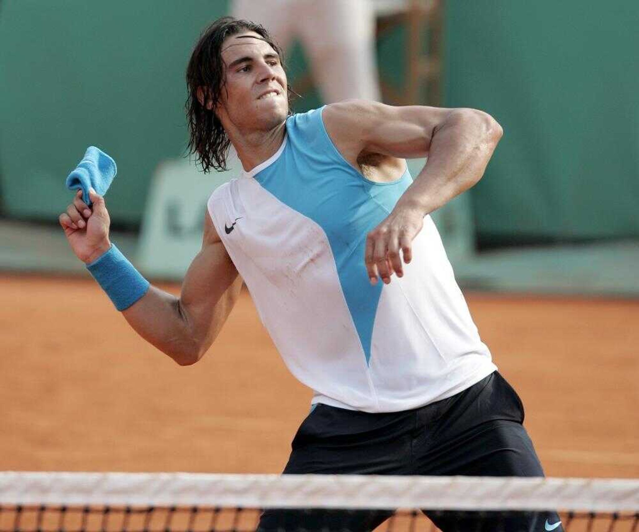 Defending champion Rafael Nadal threw his wristband to the crowd after beating Lleyton Hewitt in their fourth-round match Monday at the French Open in Paris. (FRANCOIS MORI ~ Associated Press)