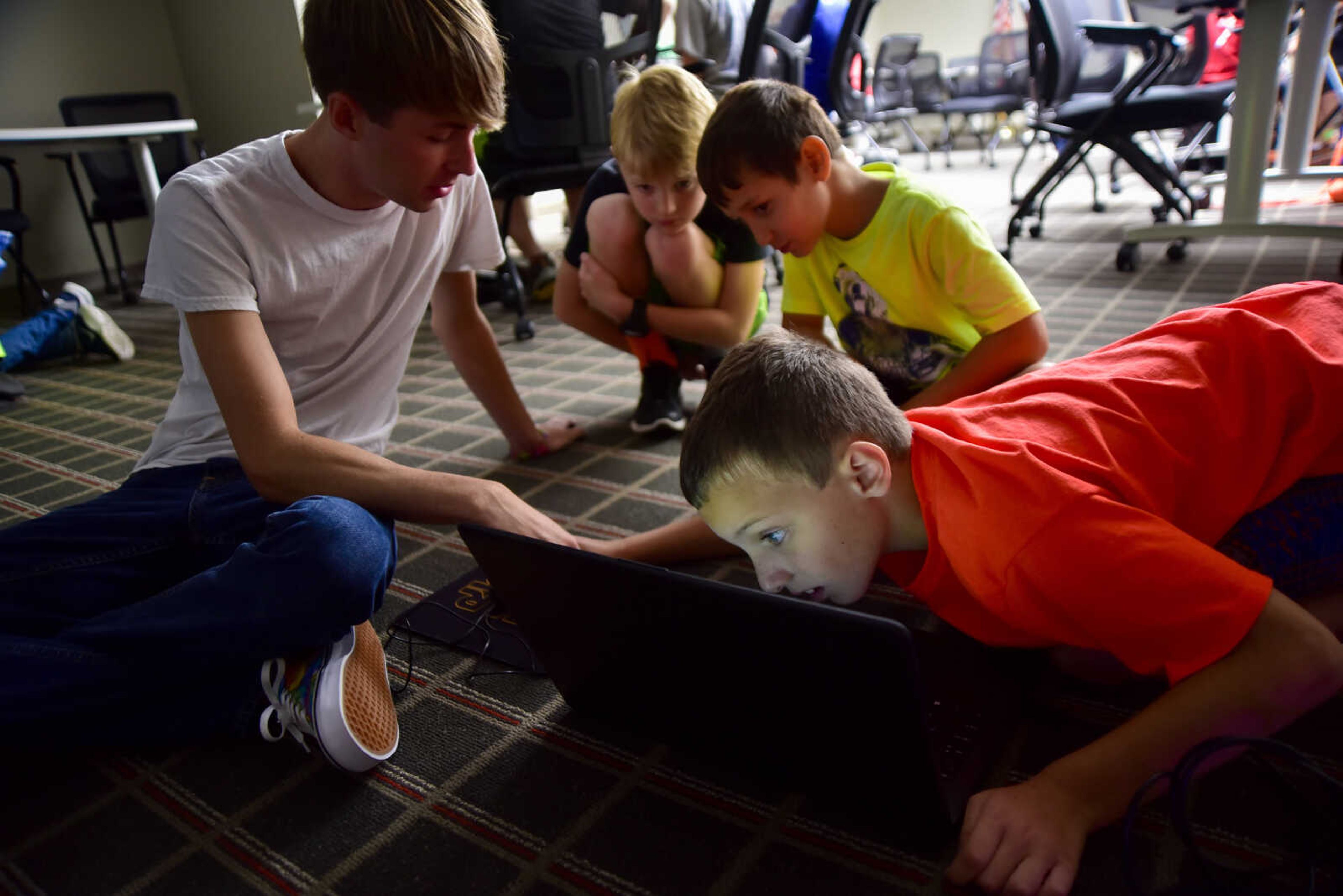 Instructor Dustin Chaney helps out a group during the Code Camp: Coding with The Finch with the Marquette Technology Institute Monday, July 17, 2017 in Cape Girardeau.