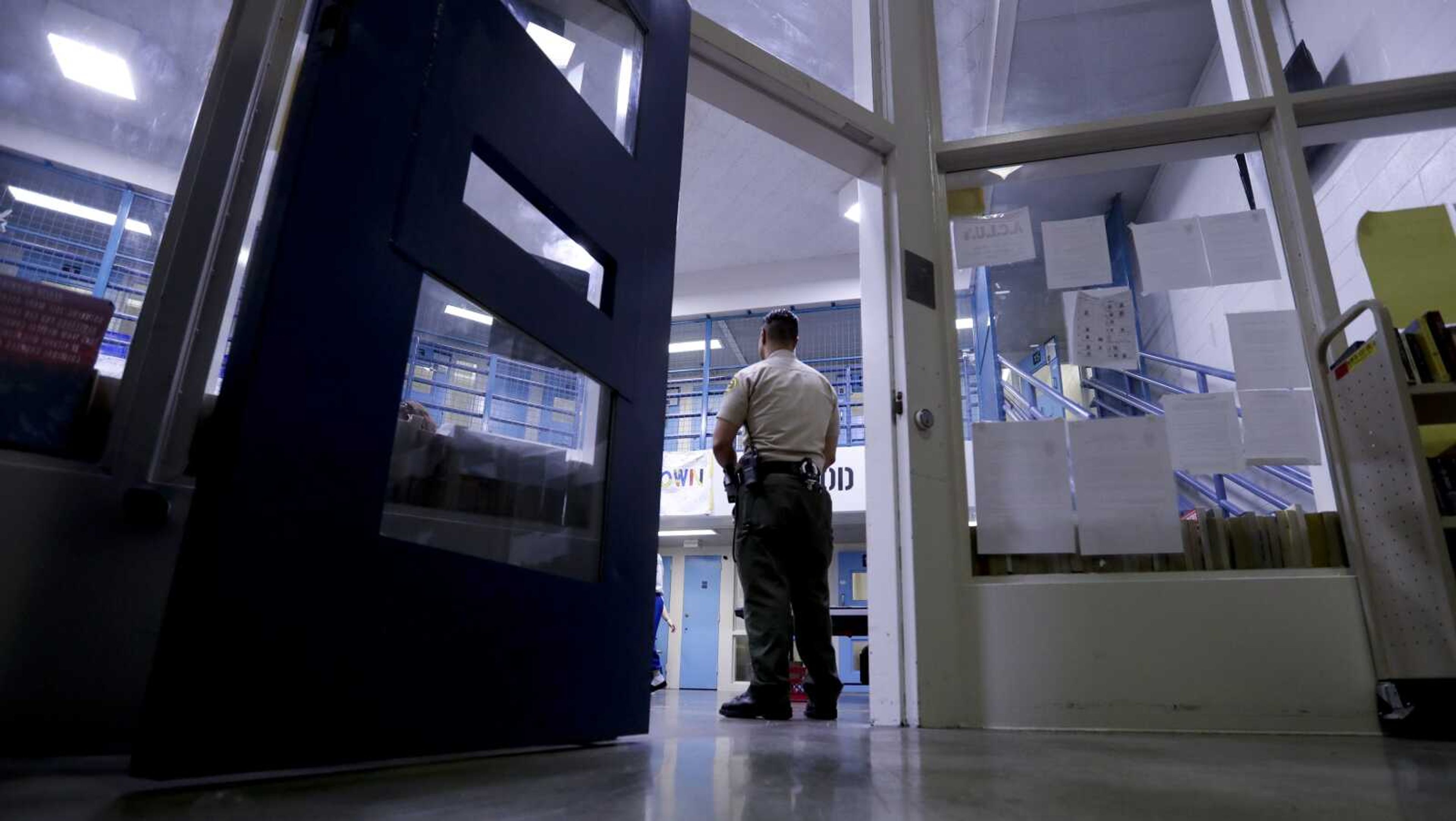 A sheriff's officer stands guard over inmates at the Twin Towers Correctional Facility on April 27, 2017, in Los Angeles. Jails across the U.S. are suffering from overcrowding, violence and abuse. It comes as staffing problems at lockups from New York to California continue to grow and have made long-simmering problems worse.