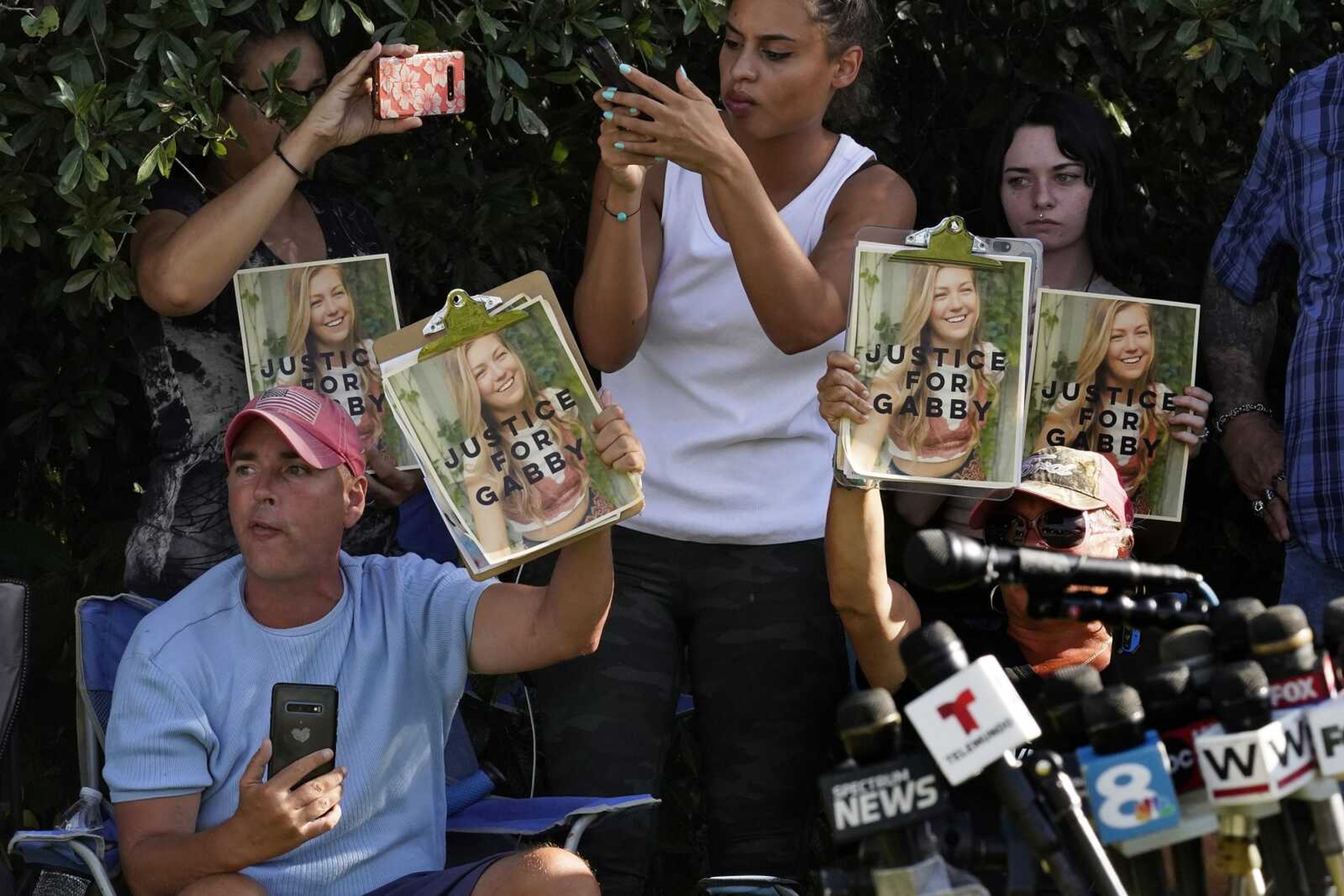 Supporters of Gabby Petito hold up photos of Gabby after a news conference Wednesday in North Port, Florida.