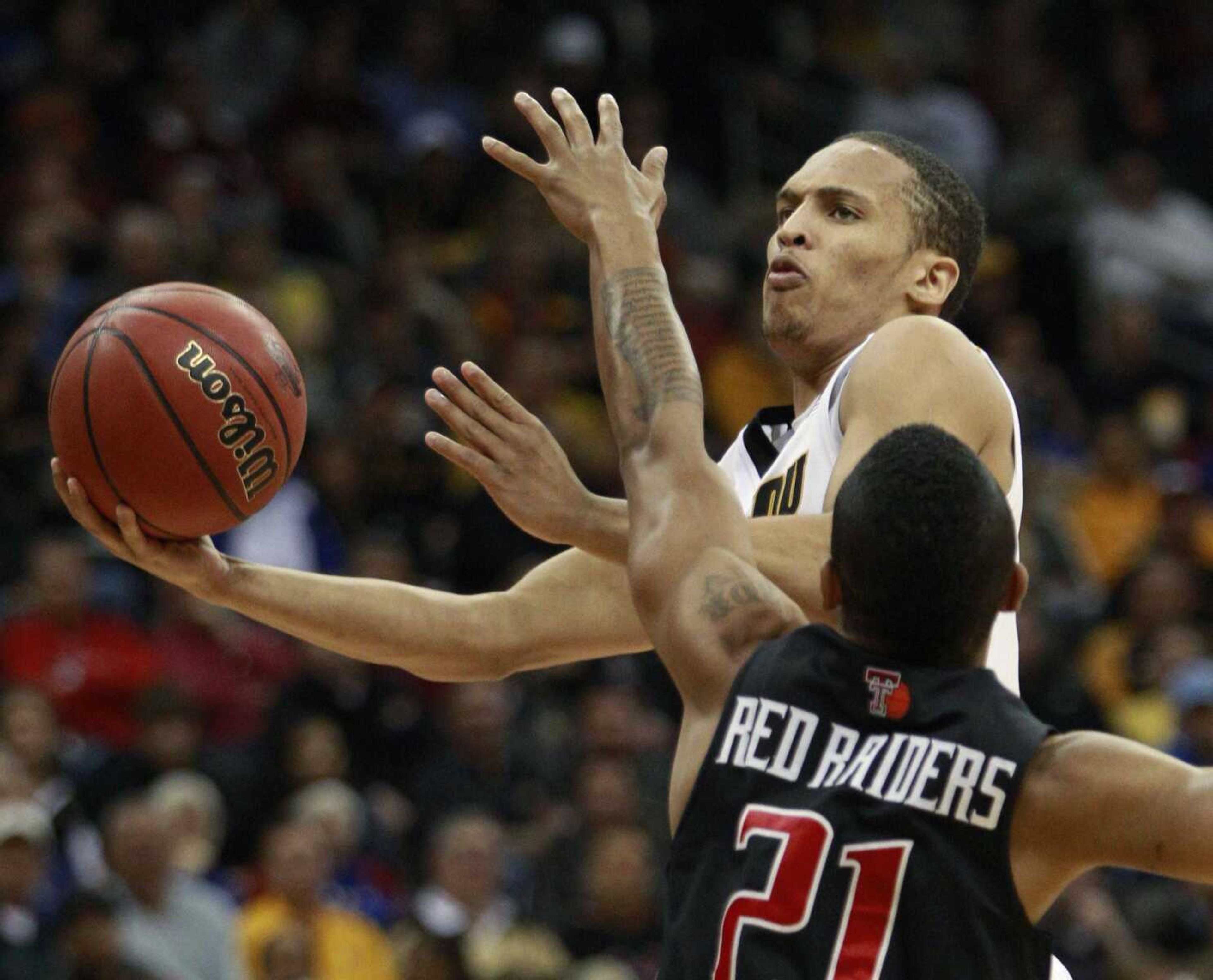 Missouri guard Michael Dixon drives the lane while being defended by Texas Tech's John Roberson during their first-round game in the Big 12 tournament Wednesday in Kansas City, Mo. (Orlin Wagner ~ Associated Press)