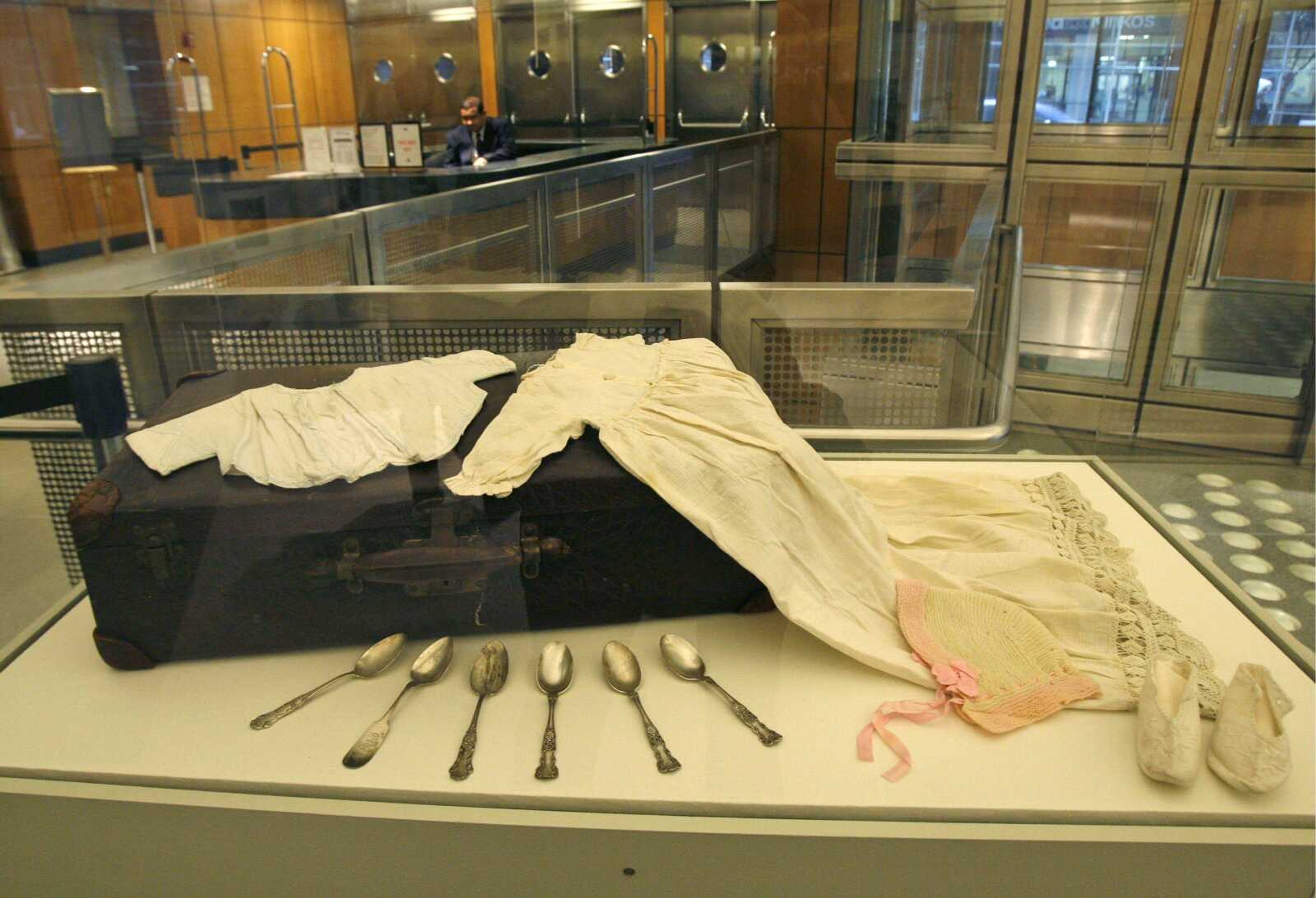 Infants' clothing and engraved silver spoons are among personal belongings discovered in a suitcase belonging to "Mrs. Ethel #20756," a patient at Willard Psychiatric Center for 43 years,  part of the New York Public Library exhibit. (KATHY WILLENS ~ Associated Press)