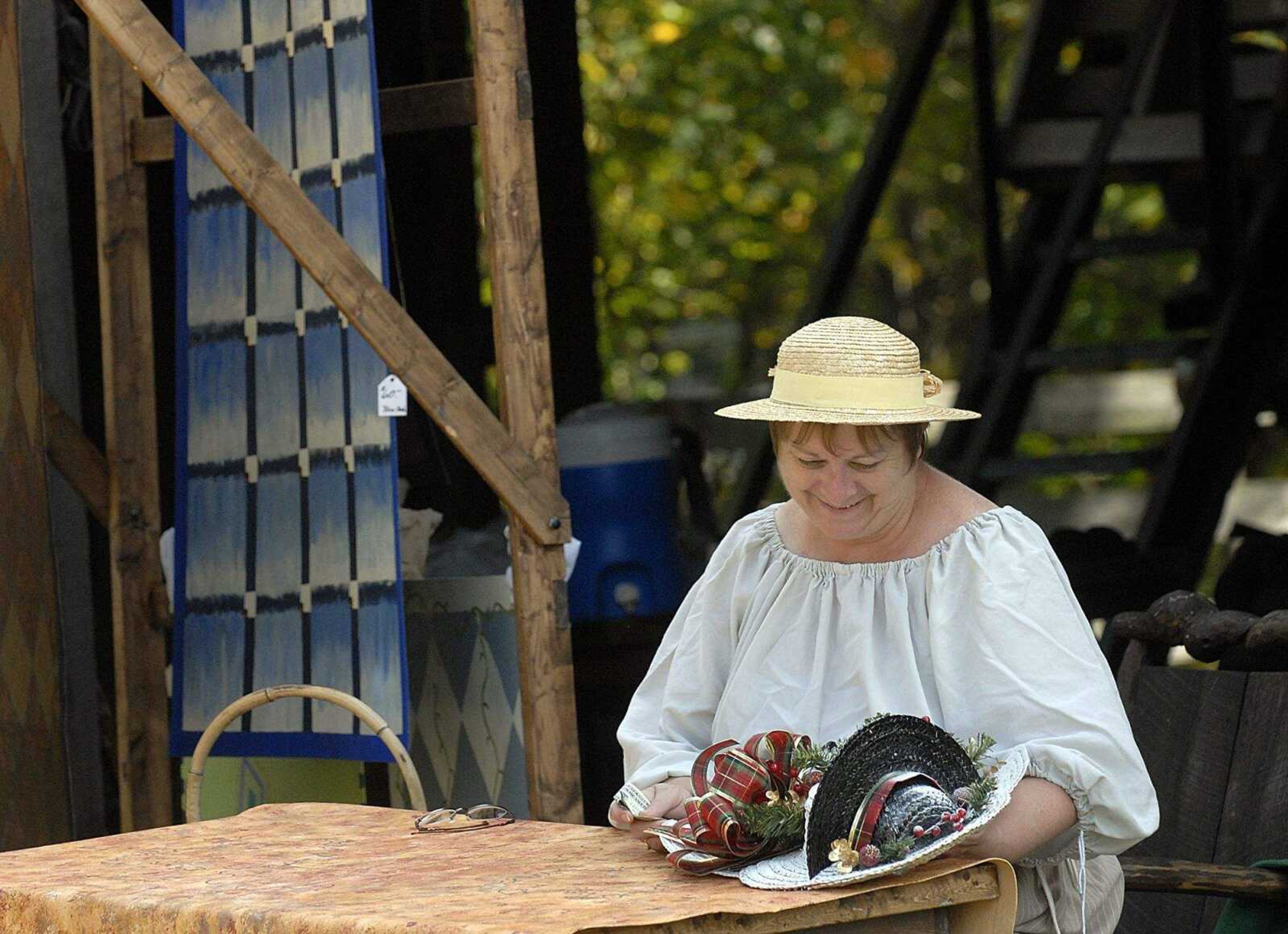 ELIZABETH DODD ~ edodd@semissourian.com
Virginia Littrell, of Iuka, Ill., admires a snowman made out of hats she purchased at the Black Forest Villages 18th Annual October Fest Saturday. Littrell paints floor cloths, a craft dating back to the 1600's.