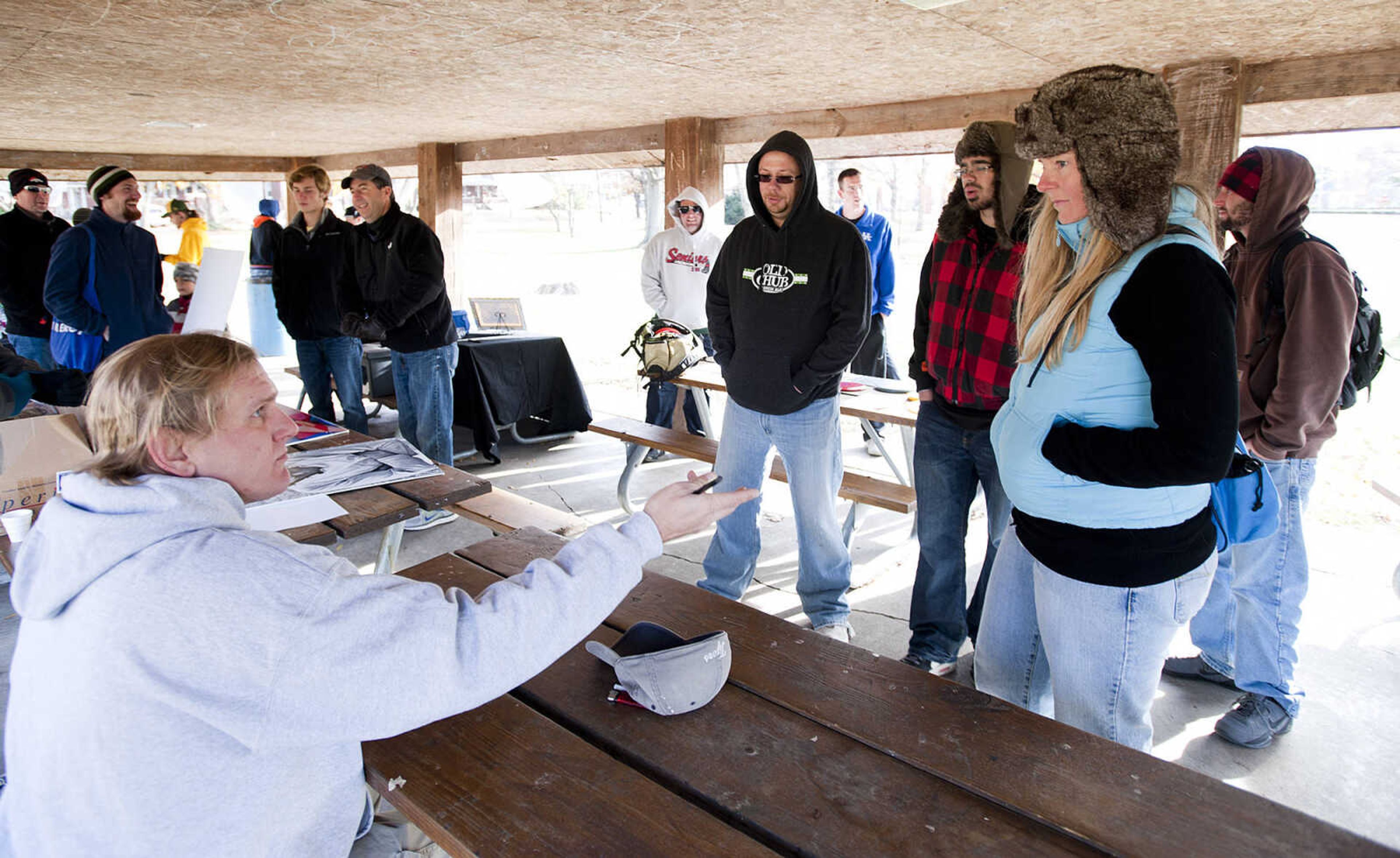 Theo Wenger, left, sells mulligans, opportunities to take another shot if you don't like your first one, before the start of the Fountain of Life Disc Golf Tournament Sunday, Nov. 24, at Capaha Park in Cape Girardeau. Stroup estimated that approximately 30 people played in the tournament which raised around $2,500 which will go towards construction of a fresh water well for a village in Swaziland, Africa.