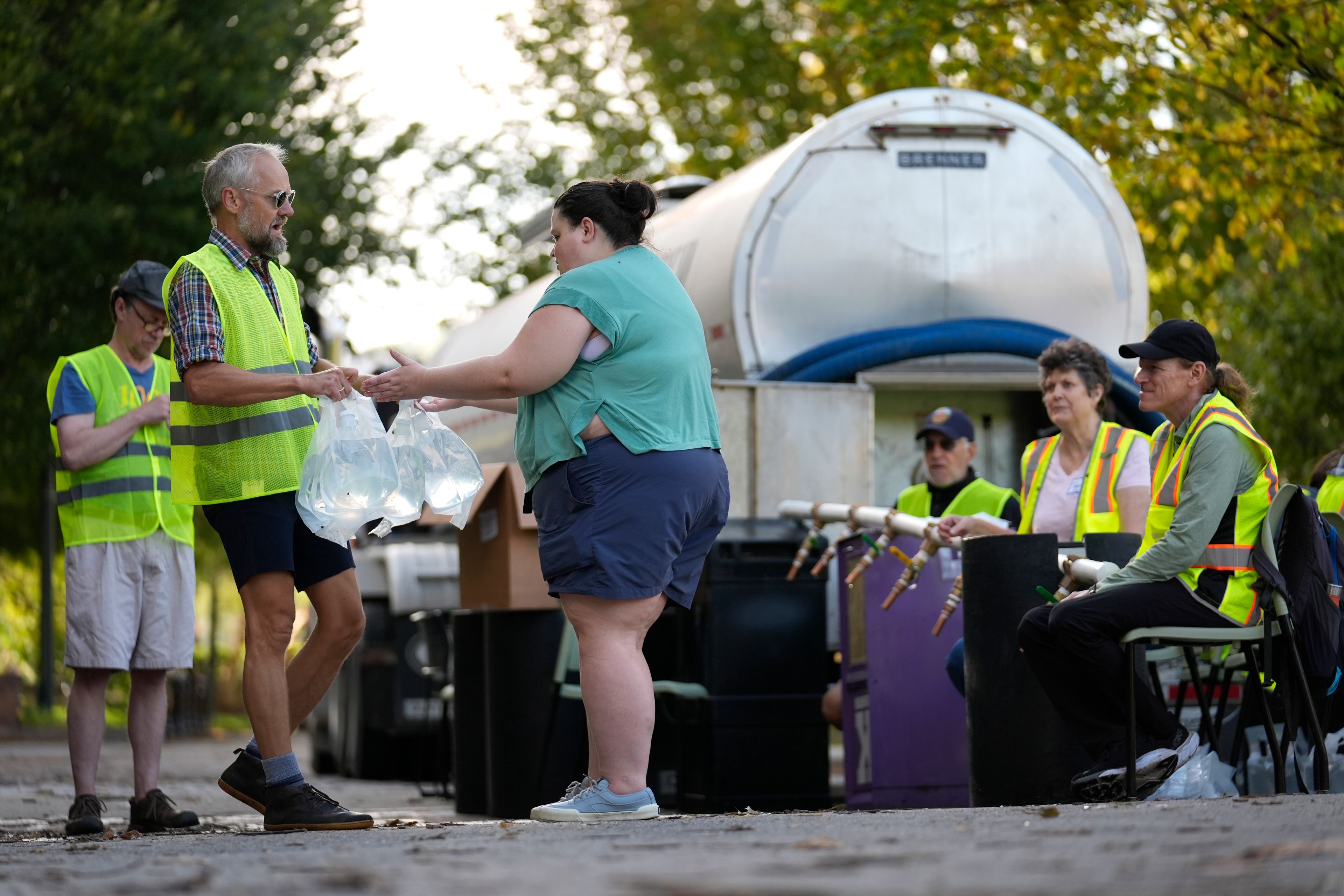 Workers hand out fresh water at a distribution site in the aftermath of Hurricane Helene Wednesday, Oct. 2, 2024, in Asheville, N.C. (AP Photo/Jeff Roberson)