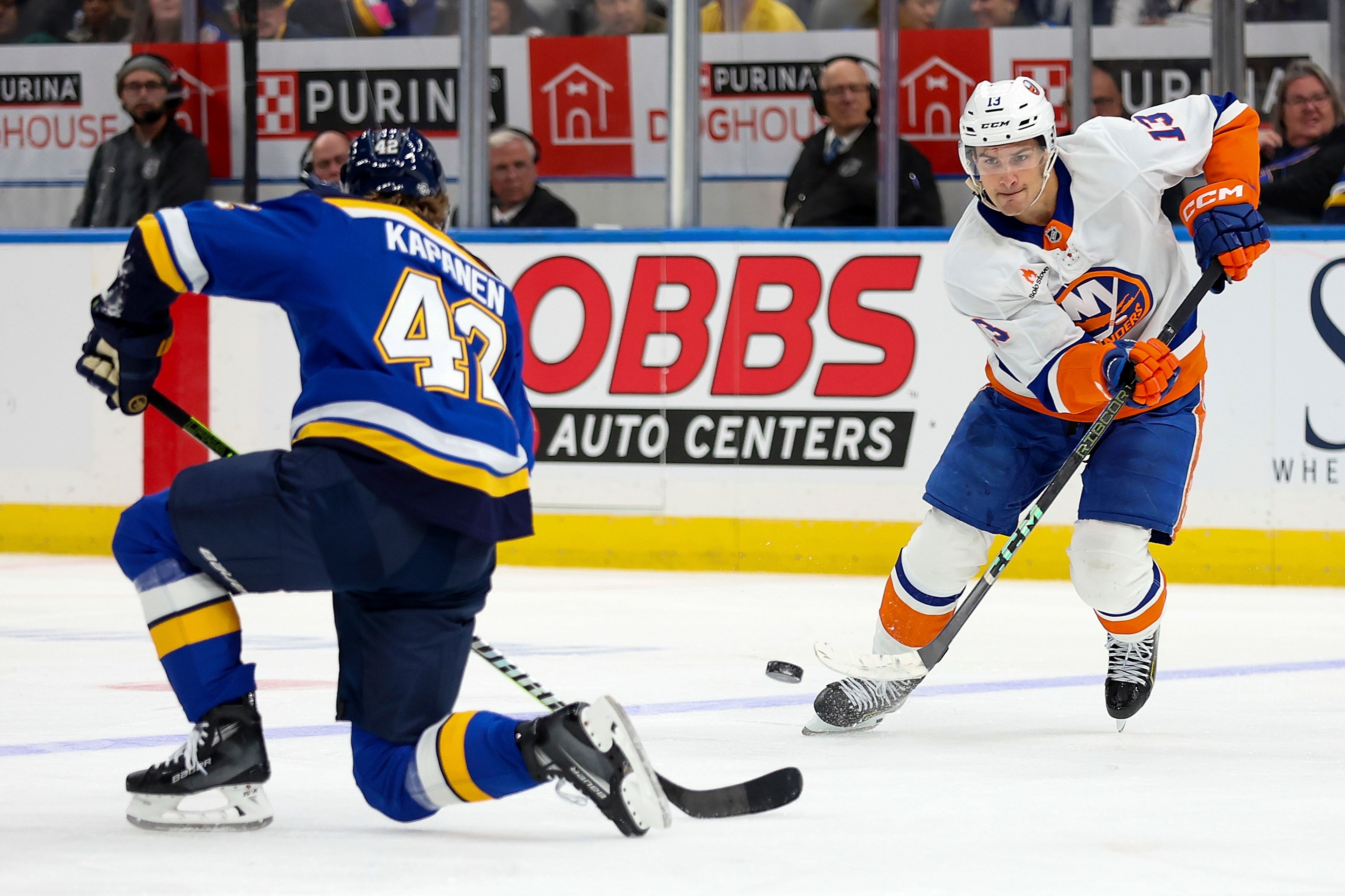 New York Islanders' Mathew Barzal (13) shoots the puck past St. Louis Blues' Kasperi Kapanen (42) during the third period of an NHL hockey game Thursday, Oct. 17, 2024, in St. Louis. (AP Photo/Scott Kane)