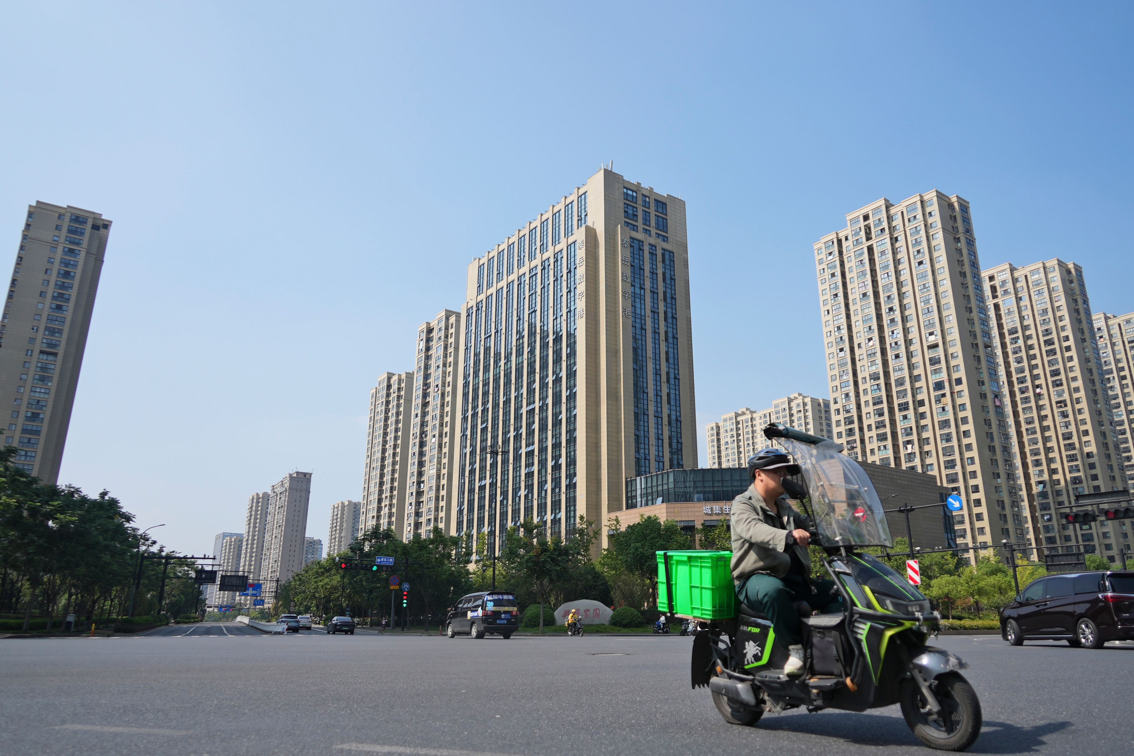 A man rides past a building identified by corporate records as housing the offices of a Chinese printing company that shipped Donald Trump's "God Bless the USA" Bible is seen in Hangzhou in China's eastern Zhejiang province, Wednesday, Oct. 9, 2024. (AP Photo/Dake Kang)