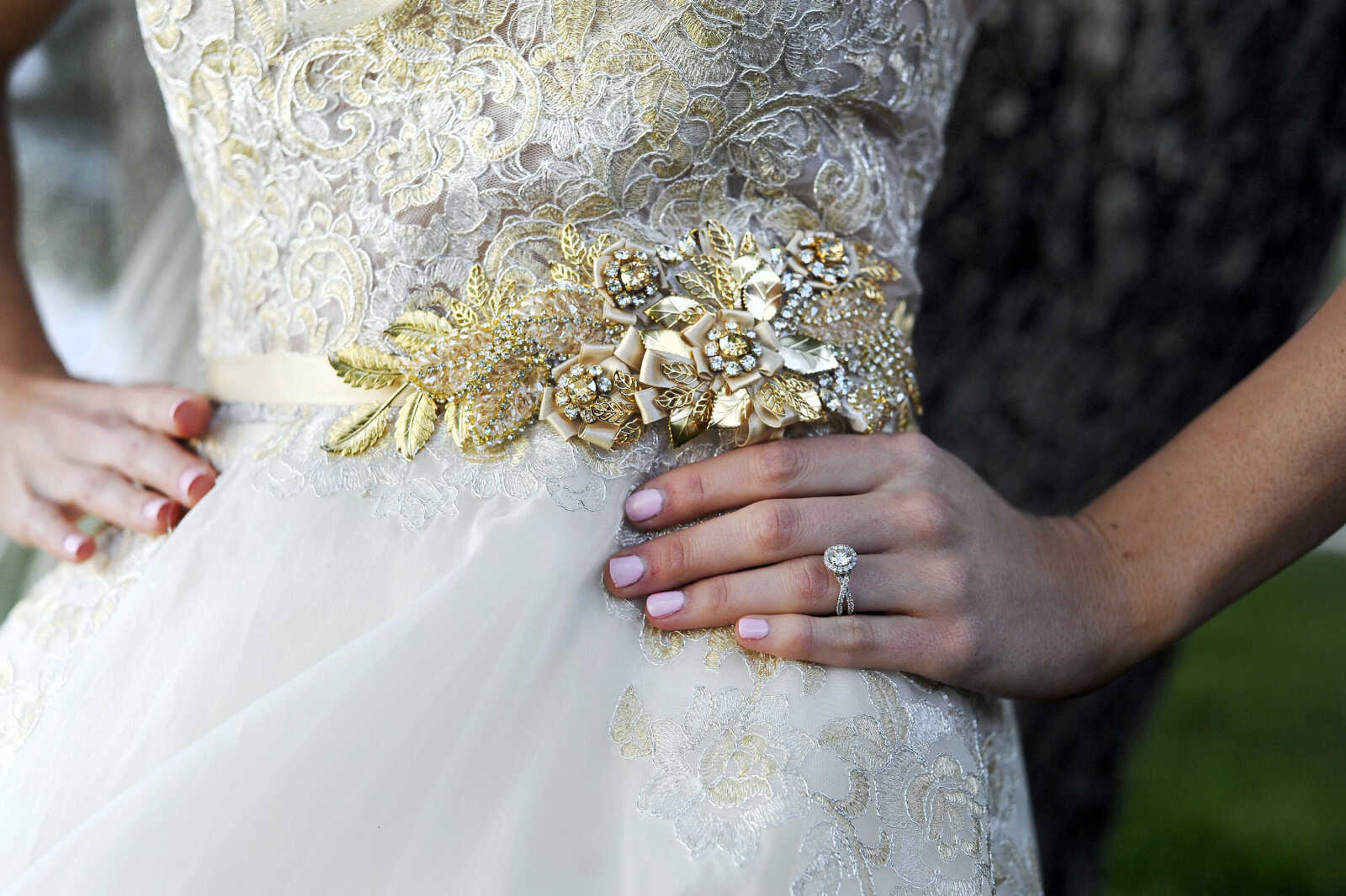 On Paige: This Tara Keely ballgown in ivory gold has an illusion scoop neckline, a V-back with cascading lace detail and an asymmetrical tiered skirt. The gown is accessorized with a glitzy gold belt and sparkle illusion cathedral-length veil, both by Lindsay Marie. Dress and accessories available at Magnolias Bridal Boutique in Cape Girardeau.

On Spencer: Manhattan slim fit tuxedo with solid black vest and black and white striped bow tie. Provided by Kim's Formal Wear and available at Garber's Men's Wear in Cape Girardeau.