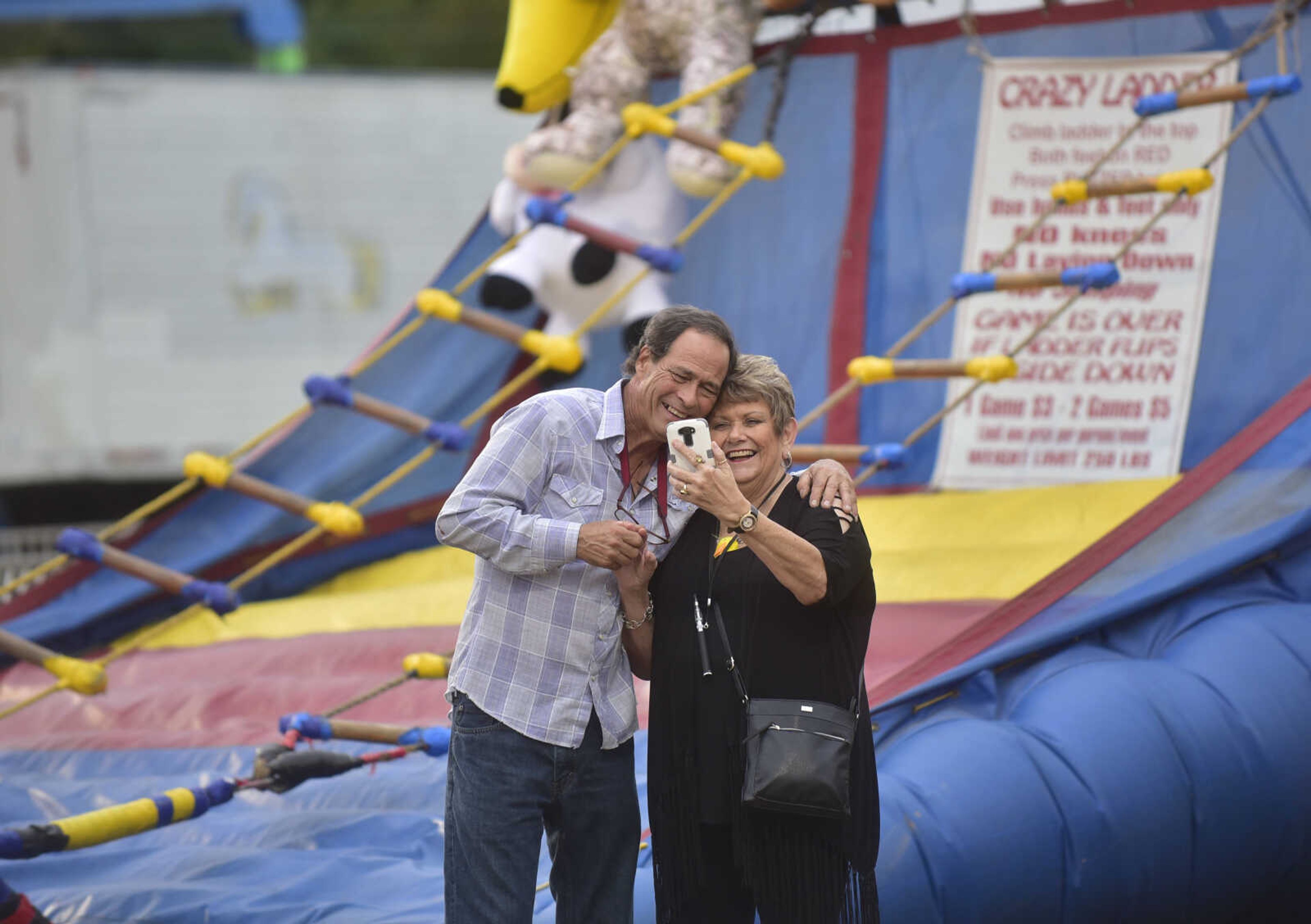 Dennis Rodriguez and Gala Rodrigues watch a video of Dennis as he attempted to climb the ladder game during the SEMO District Fair Wednesday, Sept. 13, 2017 at Arena Park in Cape Girardeau.