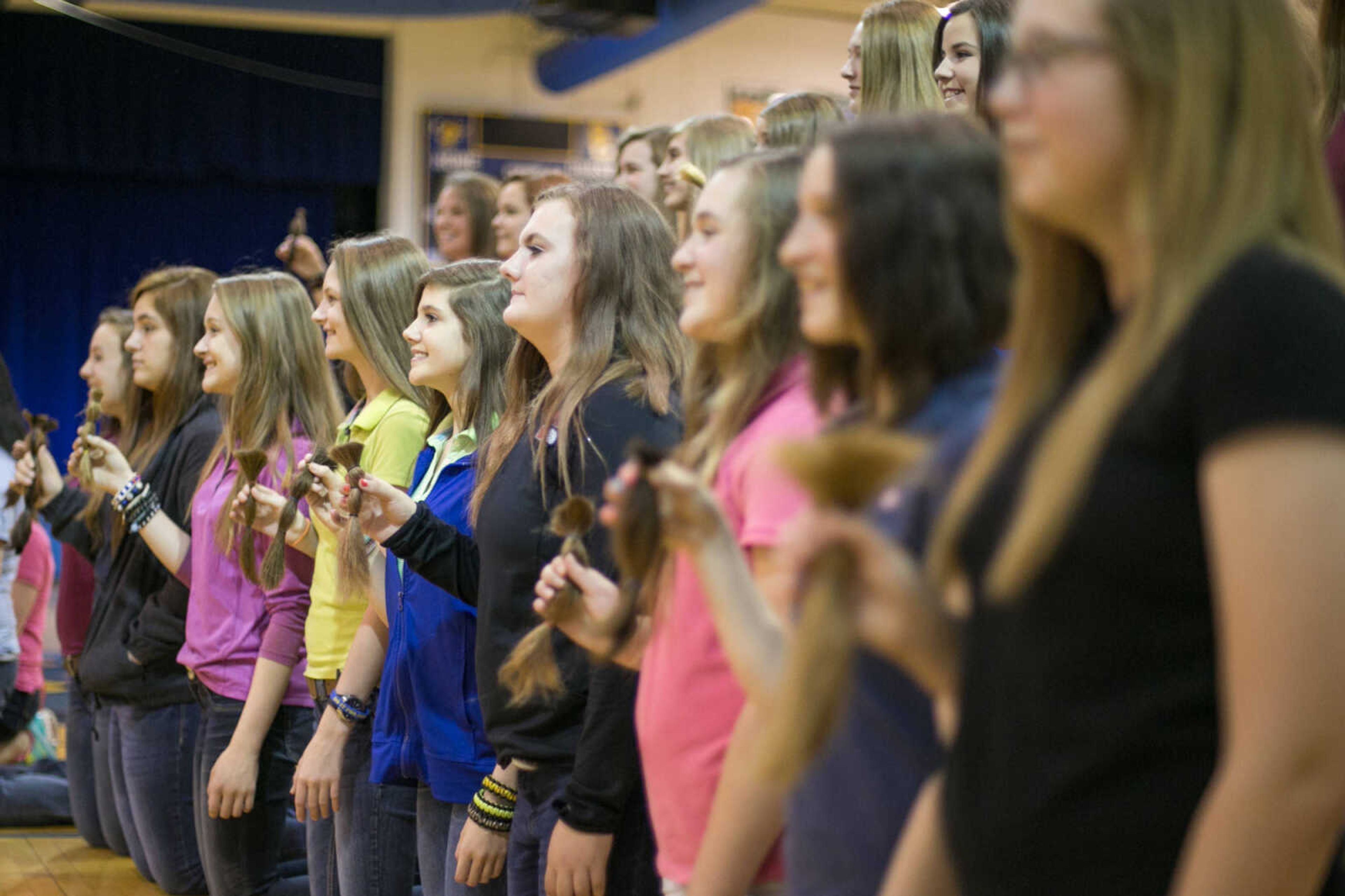 GLENN LANDBERG ~ glandberg@semissourian.com

Scott City students and teachers pose for photos with their ponytails after having their cut to be donated to the Beautiful Lengths program Monday, May 18, 2015 at Scott City High School. Twenty-four students and teachers participated in the event that provides wigs to cancer patients across the country.