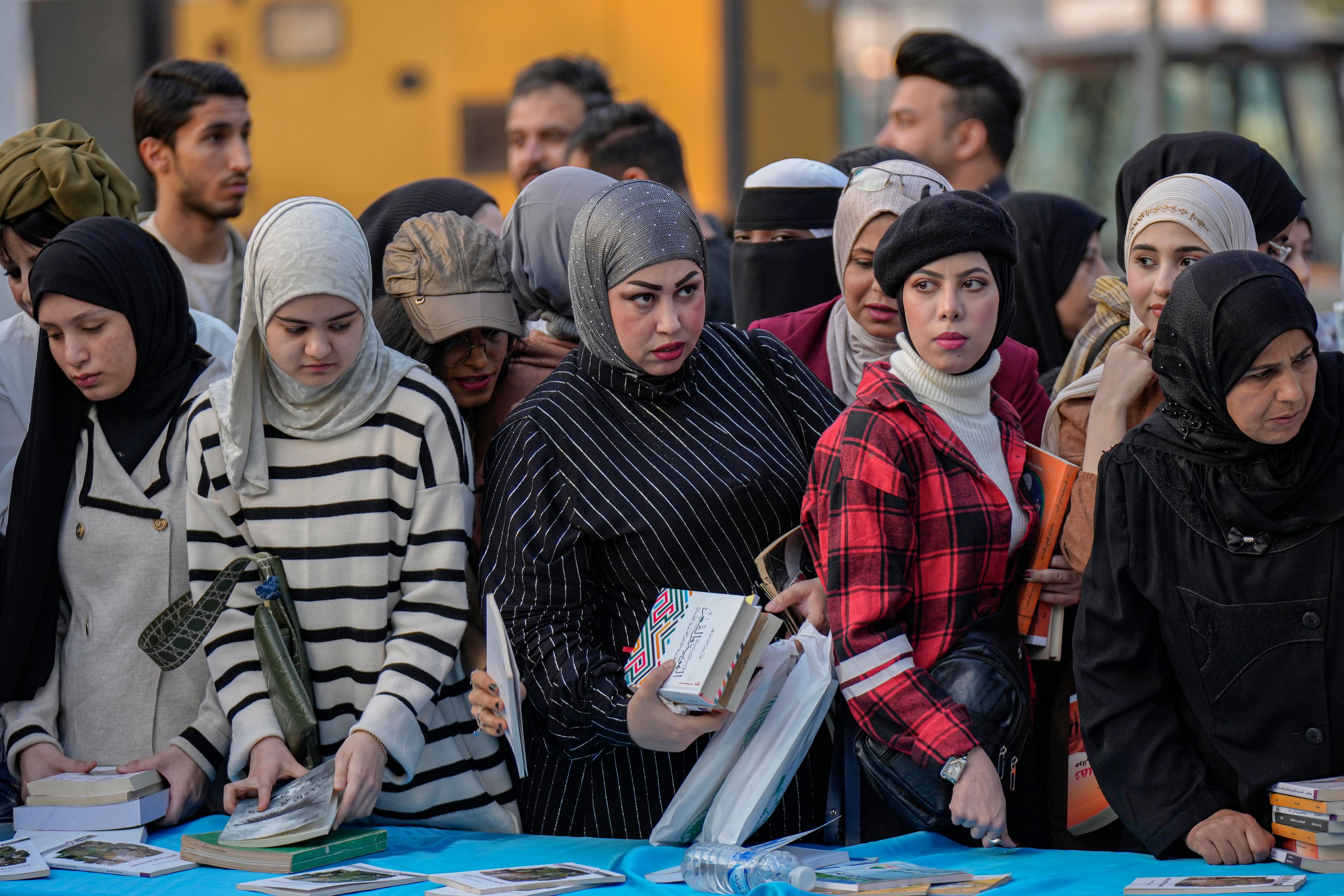 People browse through books displayed during the annual book festival in Abu Nawas street in central Baghdad, Iraq, Saturday, Nov. 16, 2024. (AP Photo/Hadi Mizban)