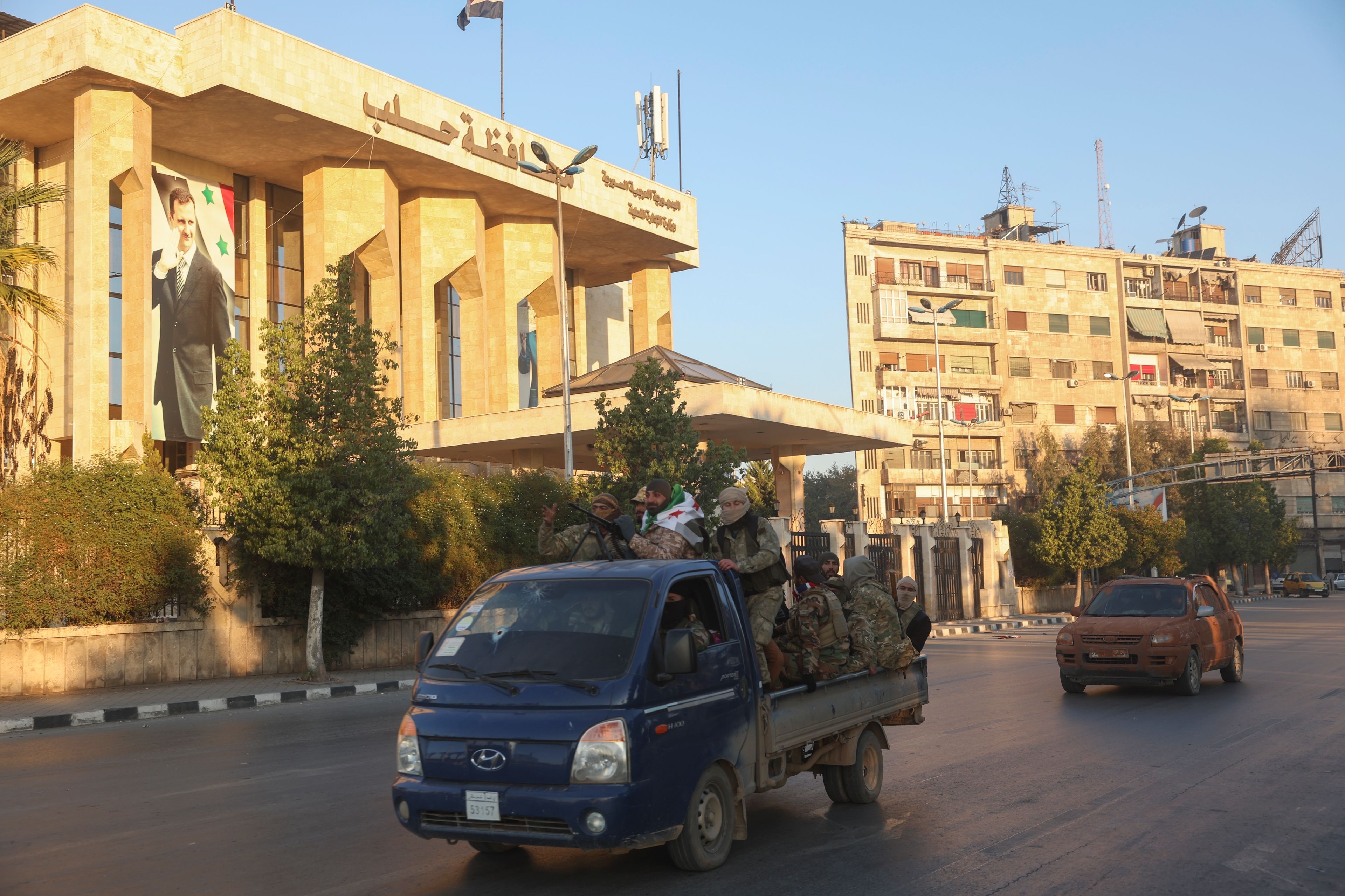 Opposition fighters ride along the streets of Aleppo, Syria, Saturday Nov. 30, 2024. (AP Photo/Ghaith Alsayed)