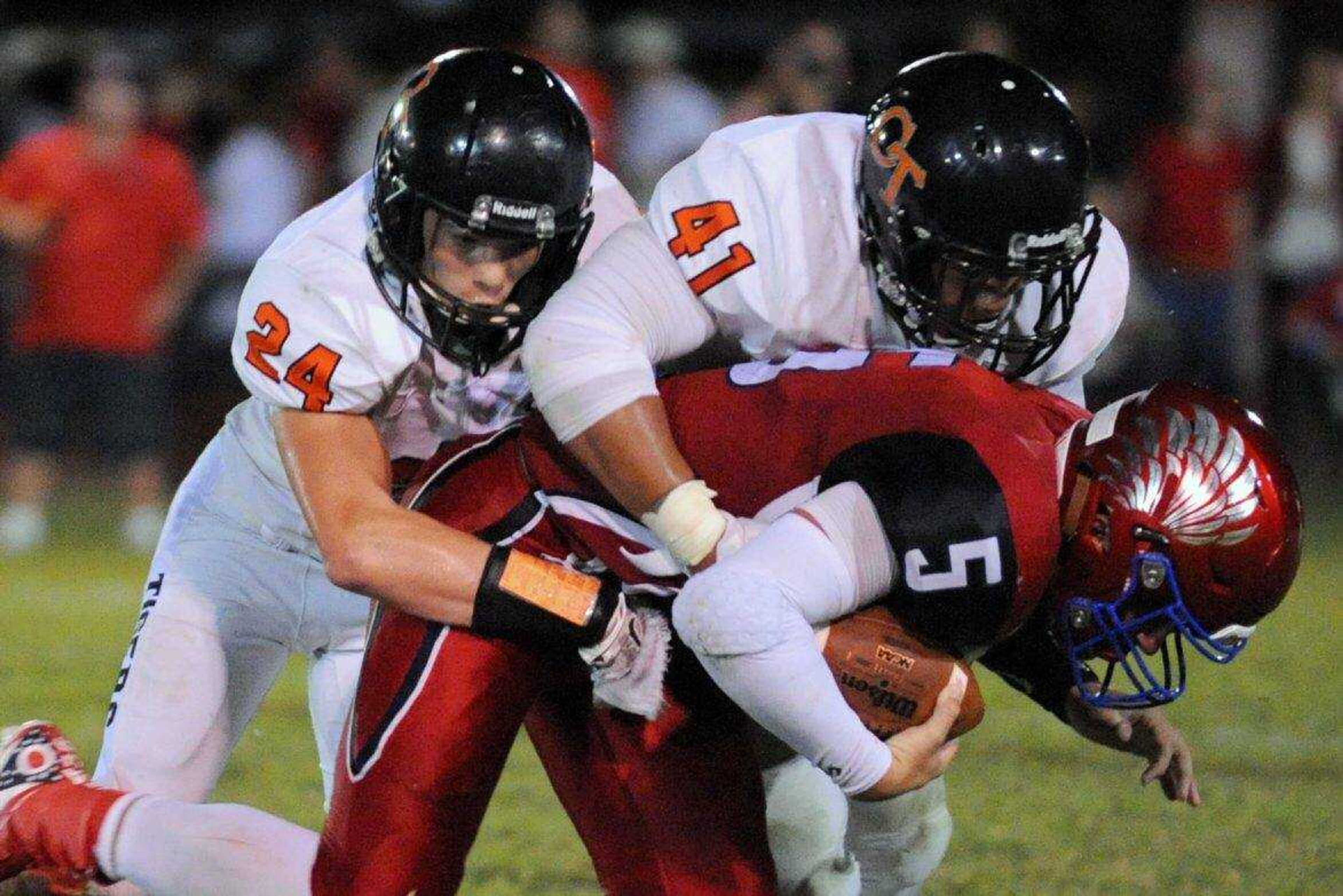 Cape Central's Matt Nussbaum, left, and Christian Mitchell combine to tackle Liberty's Josh Pruett on Friday, Aug. 19, 2016 in Mountain View, Missouri.