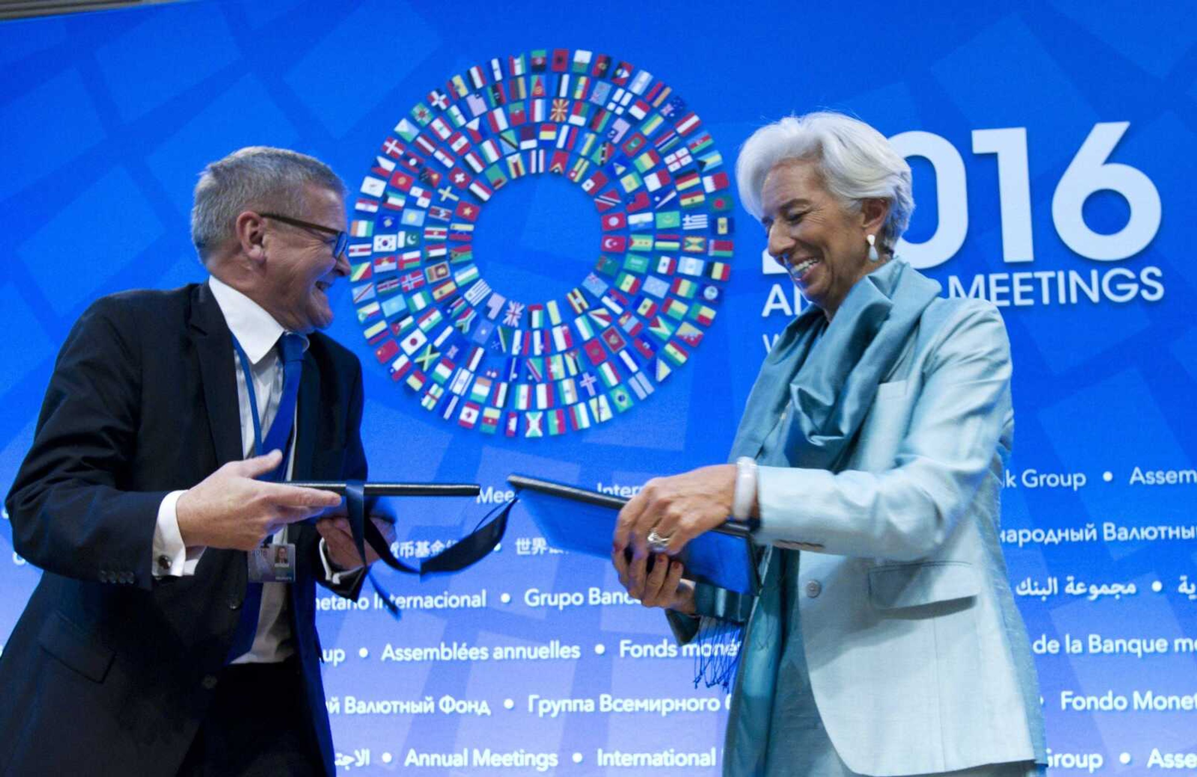 International Monetary Fund managing director Christine Lagarde exchanges documents with Danish Central Bank Governor Lars Rohde after the signing ceremony for a bilateral borrowing agreement at World Bank/IMF annual meetings at IMF headquarters in Washington on Saturday.