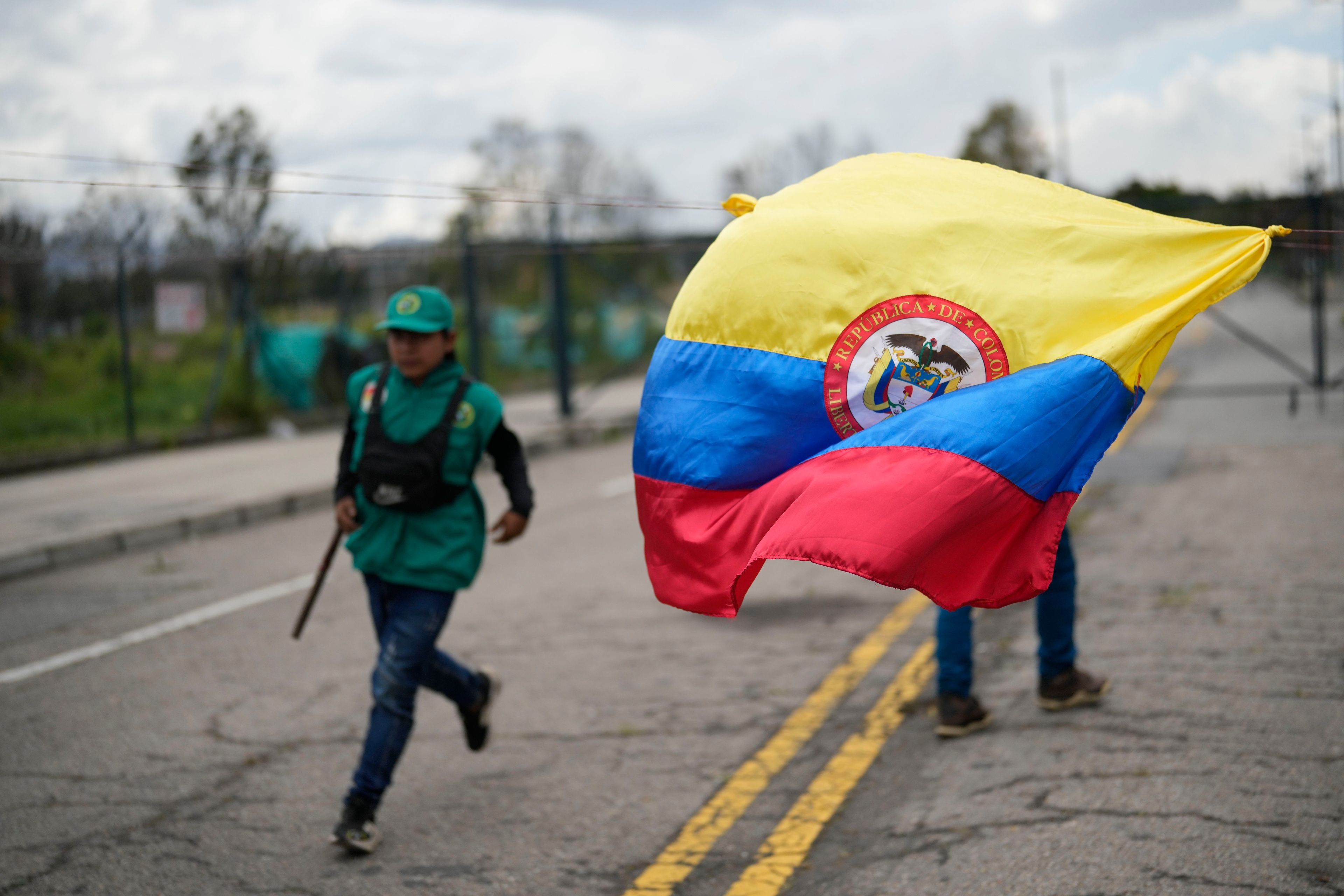 A Colombian national flag flies outside a tent encampment set up by Embera Indigenous people in Bogota, Colombia, Tuesday, Nov. 26, 2024, after arriving from the country's central western region in hopes of meeting with President Gustavo Petro regarding the precarious conditions impacting their community. (AP Photo/Fernando Vergara)