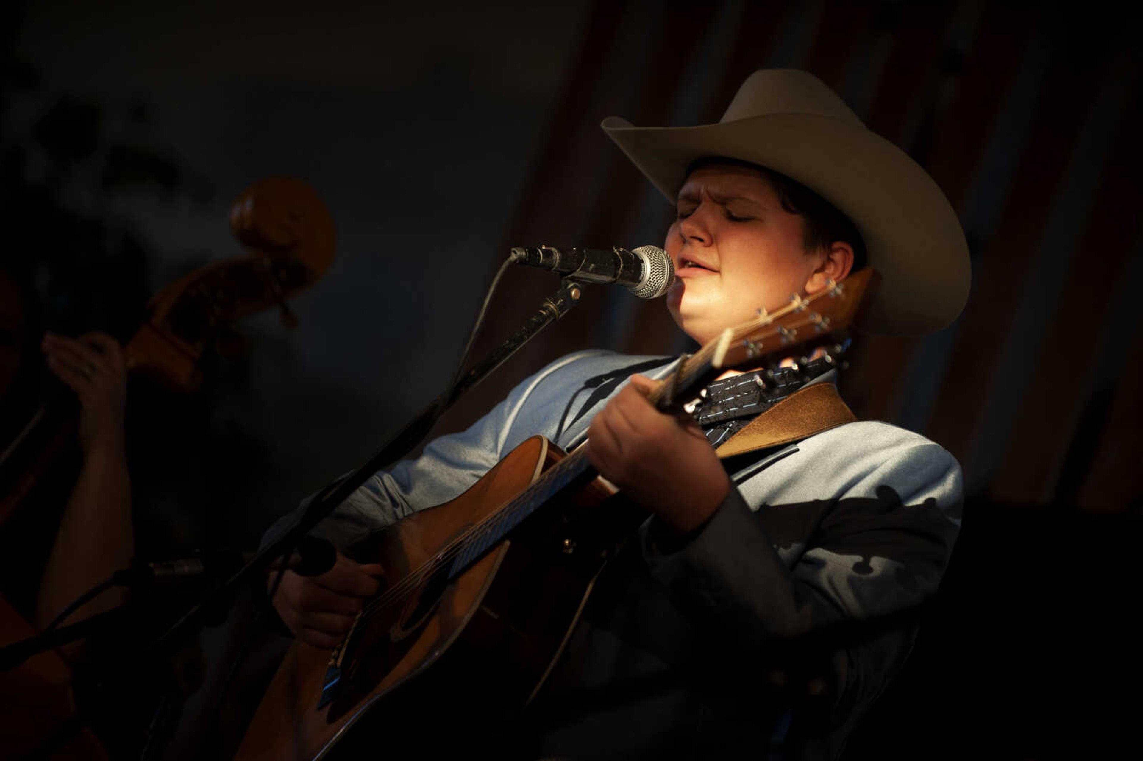 Elijah Baker of Birch Tree, Missouri, 15, plays guitar while performing with his mother and siblings at the Bootheel Bluegrass Festival on Friday, Jan. 25, 2019, at the Bavarian Halle in Fruitland.&nbsp;