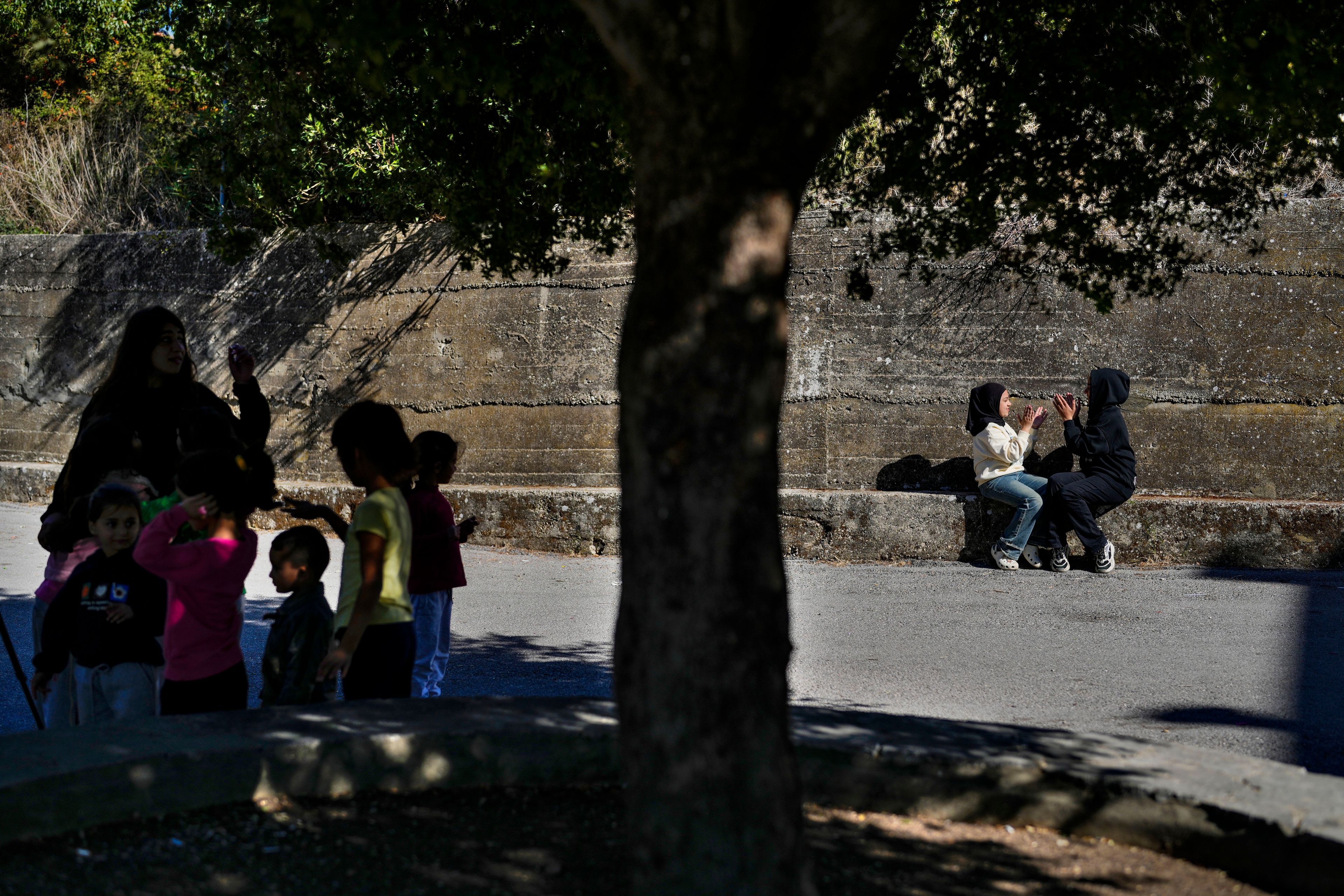 Displaced children who fled southern Lebanon with their families during the ongoing Hezbollah-Israel war play outside a school in the village of Ebrine, northern Lebanon, Thursday, Oct. 24, 2024. (AP Photo/Hassan Ammar)