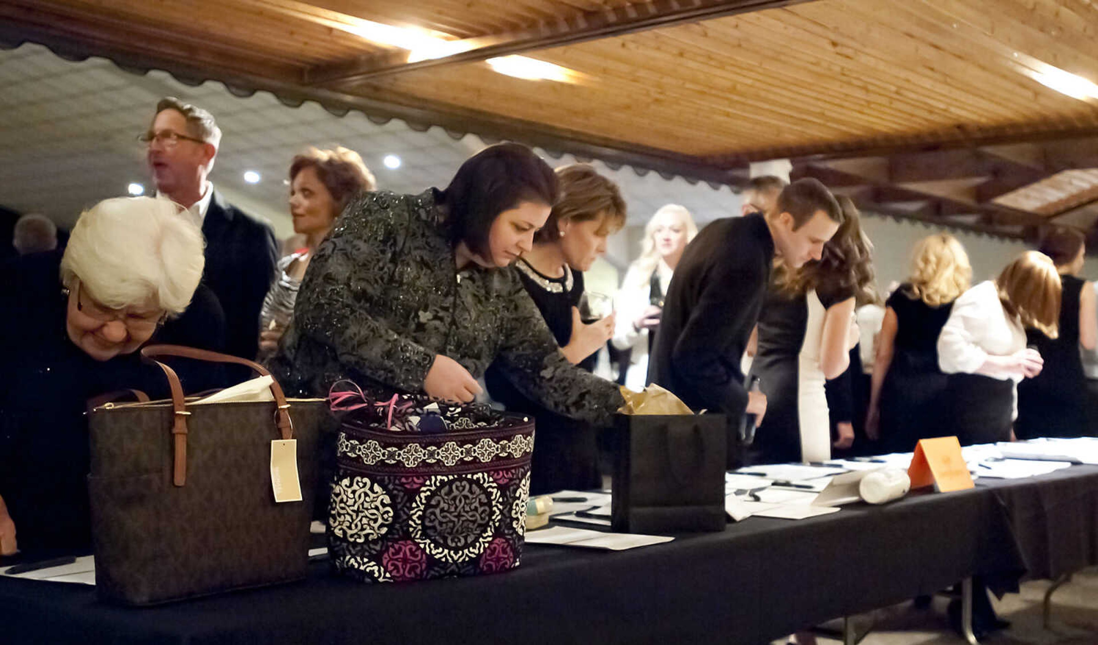 Attendees look over items up for bid in a silent auction at the Cape Girardeau Public School Foundation Penguin Party Saturday, Feb. 8, at Plaza by Ray's in Cape Girardeau. The event, which is the foundation's annual fundraiser, featured a sit down plated dinner, a live and silent auction followed by dancing.