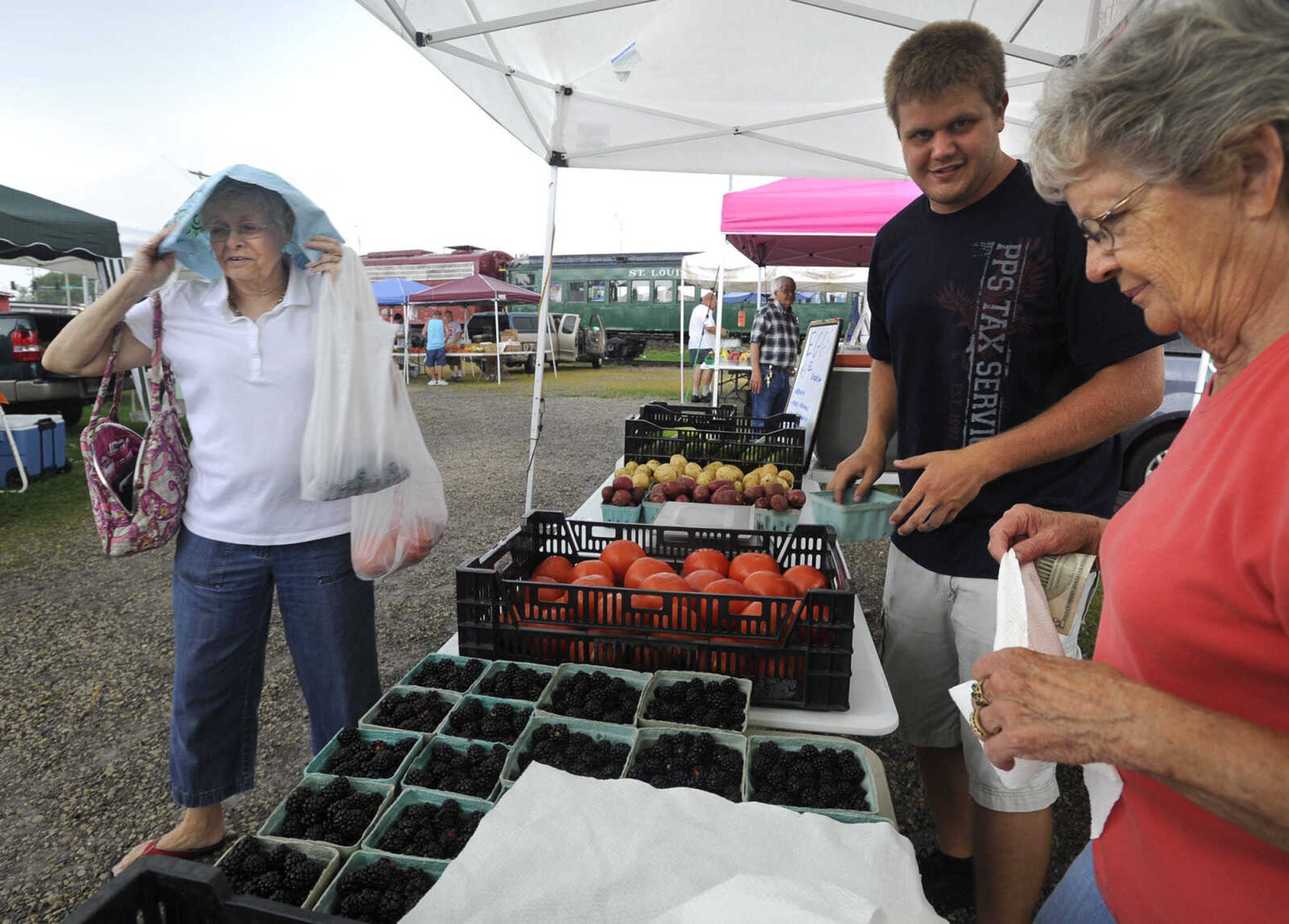 Mary Margaret Wiginton of Jackson takes her purchases from Lance Menard and Ruth Menard Tuesday, July 7, 2015 at the Jackson Farmer's Market in Jackson.