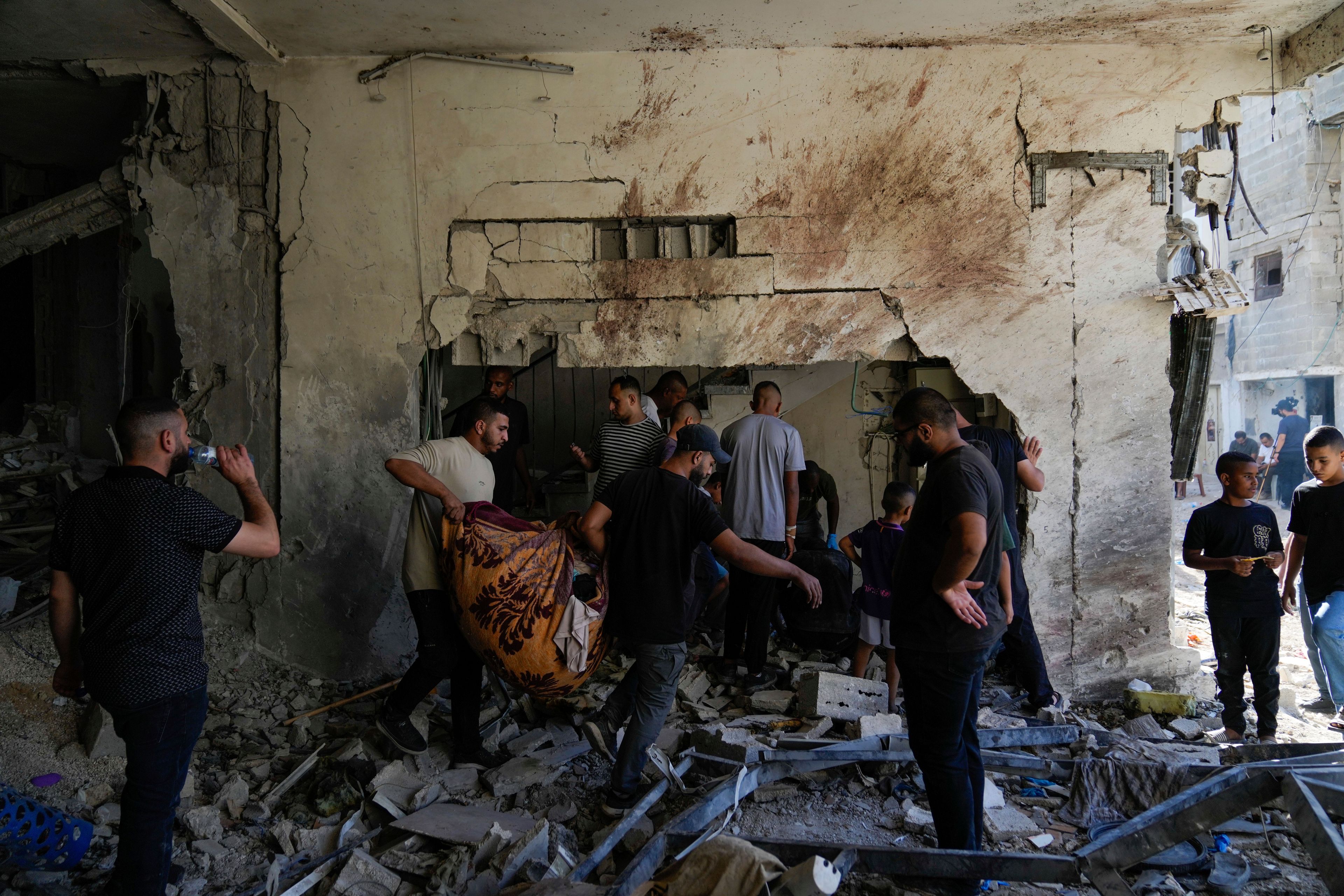 Palestinians examine the damage following an Israeli airstrike in the West Bank city of Tulkarem, which Palestinian health officials say killed 18 people and the Israeli military says took out a Hamas leader, on Friday, Oct. 4, 2024. (AP Photo/Nasser Nasser)