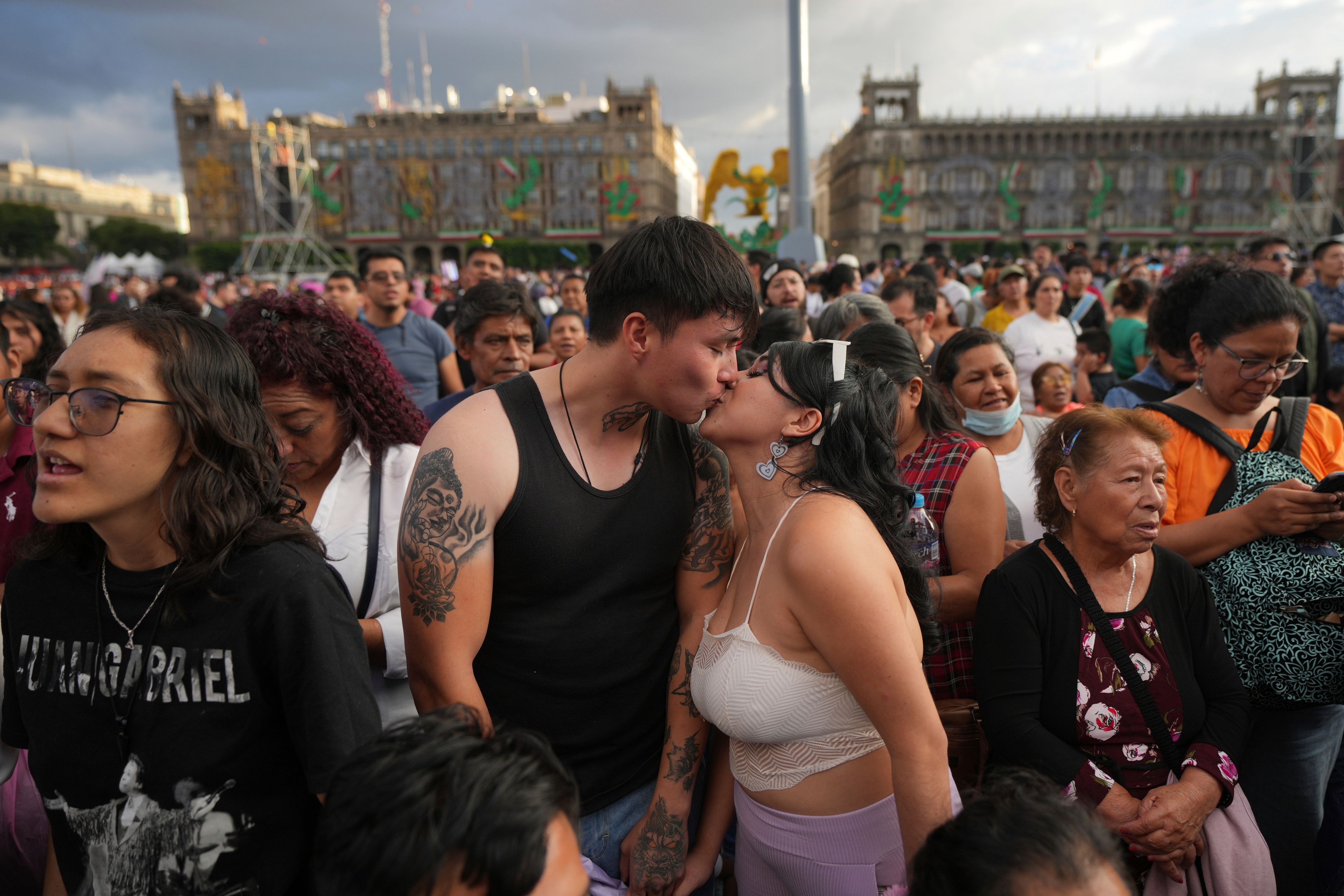 Alan Castaneda kisses his girlfriend Ingrid Flores prior an exhibition in memory of late Mexican pop star Juan Gabriel at the Zocalo, Mexico City's main square, Sunday, Sept. 22, 2024. (AP Photo/Fernando Llano)