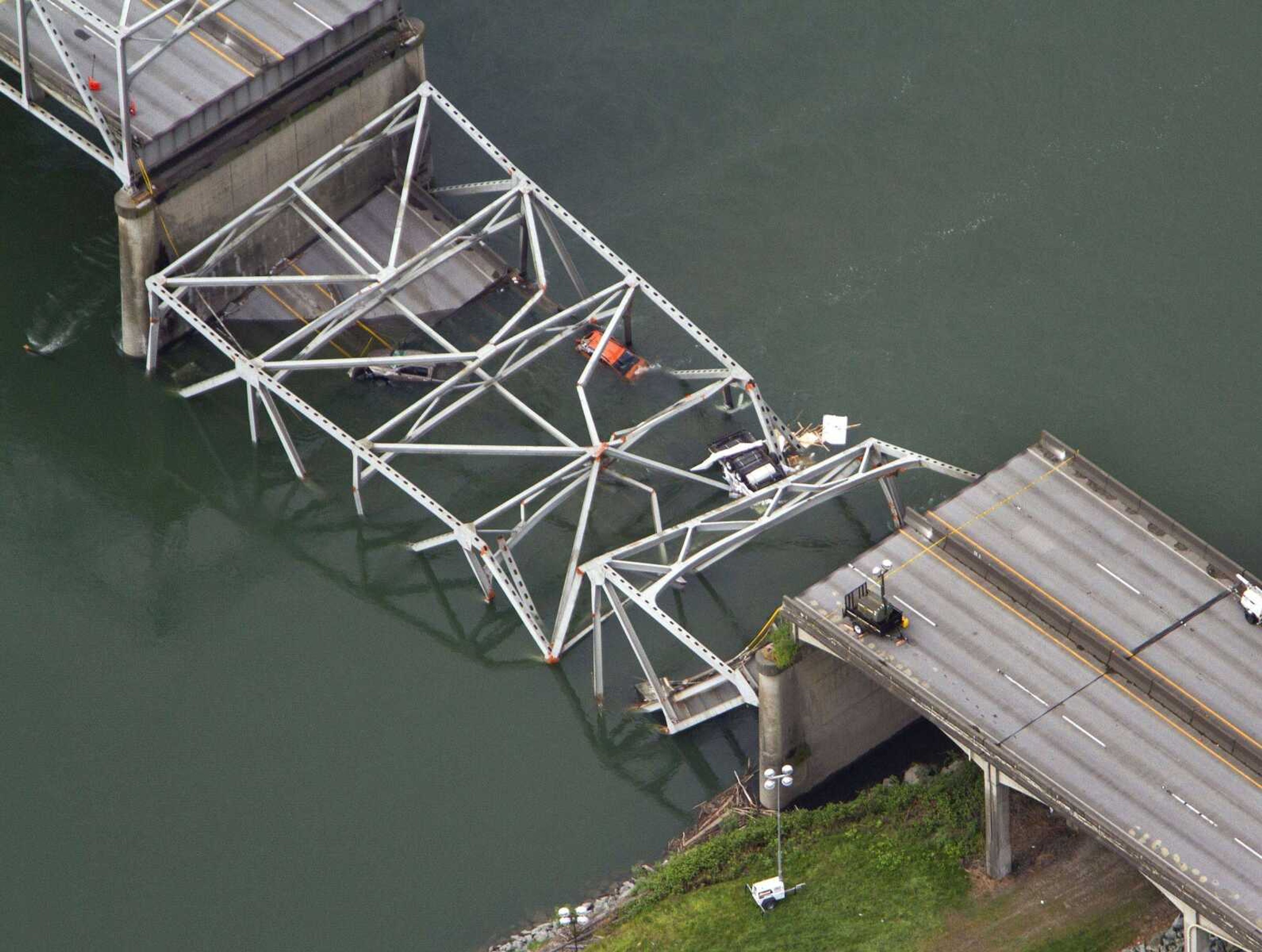 A collapsed section of the Interstate 5 bridge over the Skagit River is seen in an aerial view Friday, May 24, 2013, in Mt. Vernon, Wash. Part of the bridge collapsed Thursday evening, sending cars and people into the water when a an oversized truck hit the span, the Washington State Patrol chief said. Washington Gov. Jay Inslee on Friday declared a state of emergency in three counties around the bridge, saying that the bridge collapse has caused extensive disruption, impacting the citizens and economy in Skagit, Snohomish and Whatcom Counties. (AP Photo/The Seattle Times, Mike Siegel) MAGS OUT; NO SALES; SEATTLEPI.COM OUT; MANDATORY CREDIT