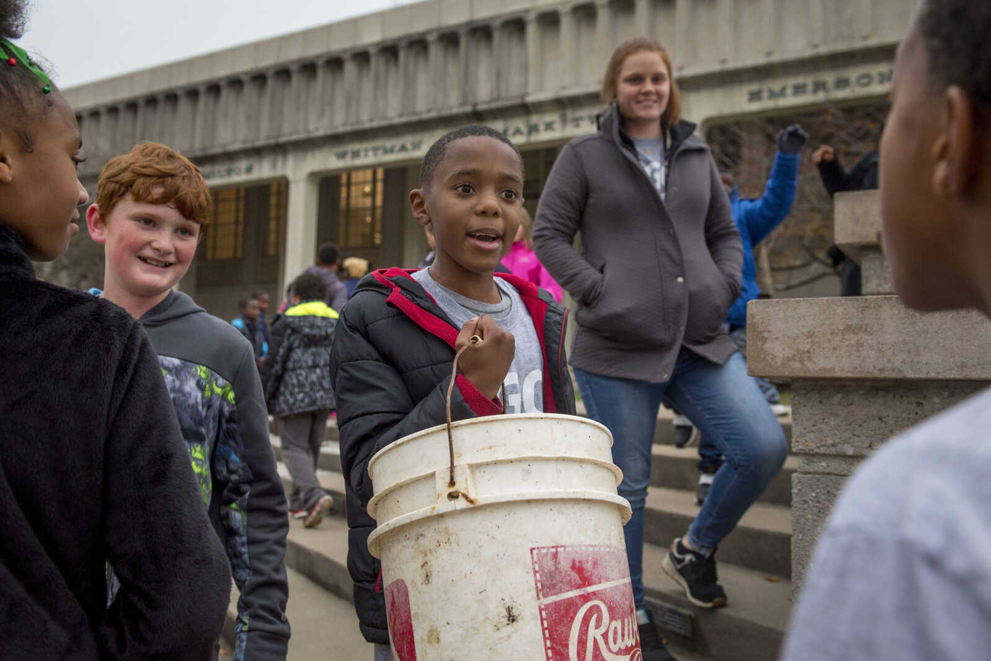 Jefferson Elementary students Michael Curry, center, and Gavin Deimund, left, carry trash they picked up on the Southeast Missouri State University campus as part of a beautification project Monday.