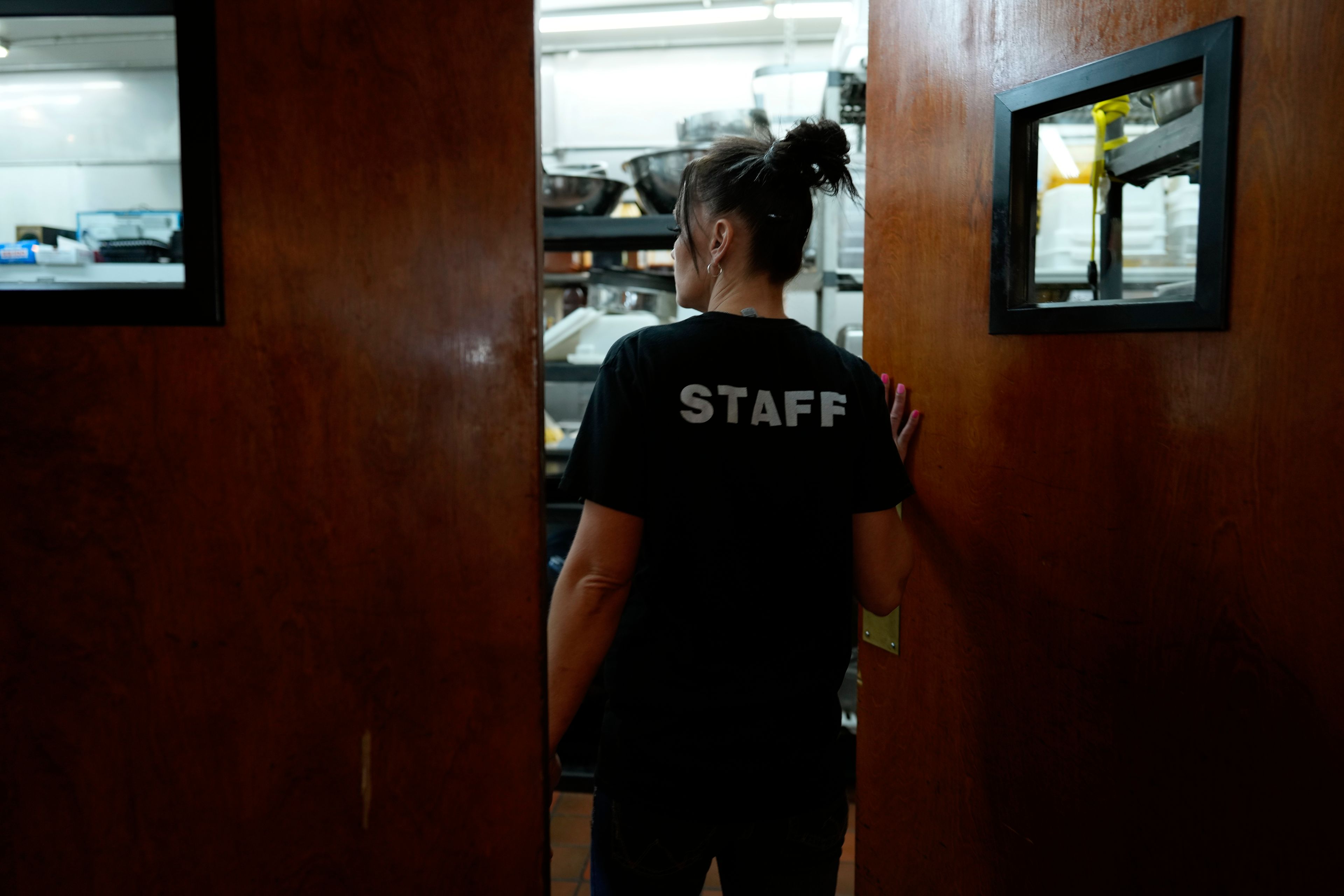 April Youst enters the kitchen of a restaurant where she works, Wednesday, Oct. 9, 2024, in West Virginia. (AP Photo/Carolyn Kaster)