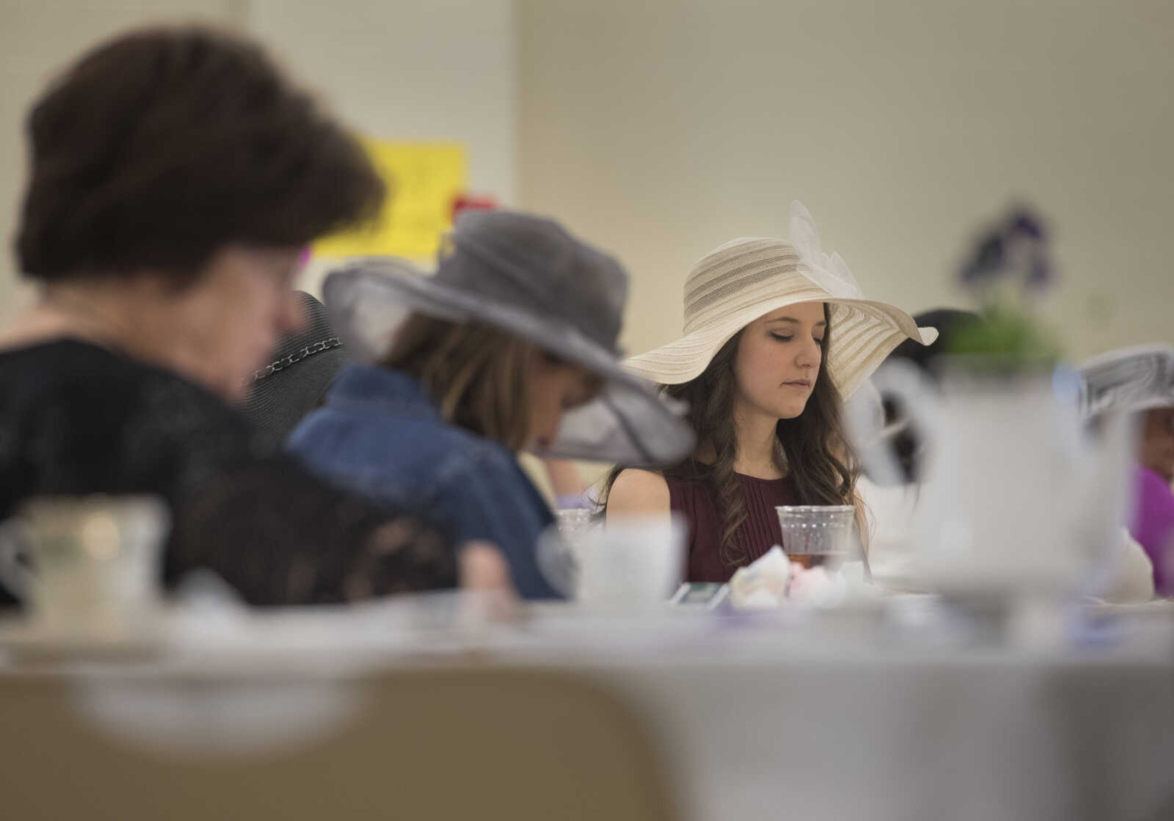 Women pray during a ladies' tea and sweets event hosted by Stop Needless Acts of Violence Please on April 1, 2017 at the Shawnee Park Center in Cape Girardeau.