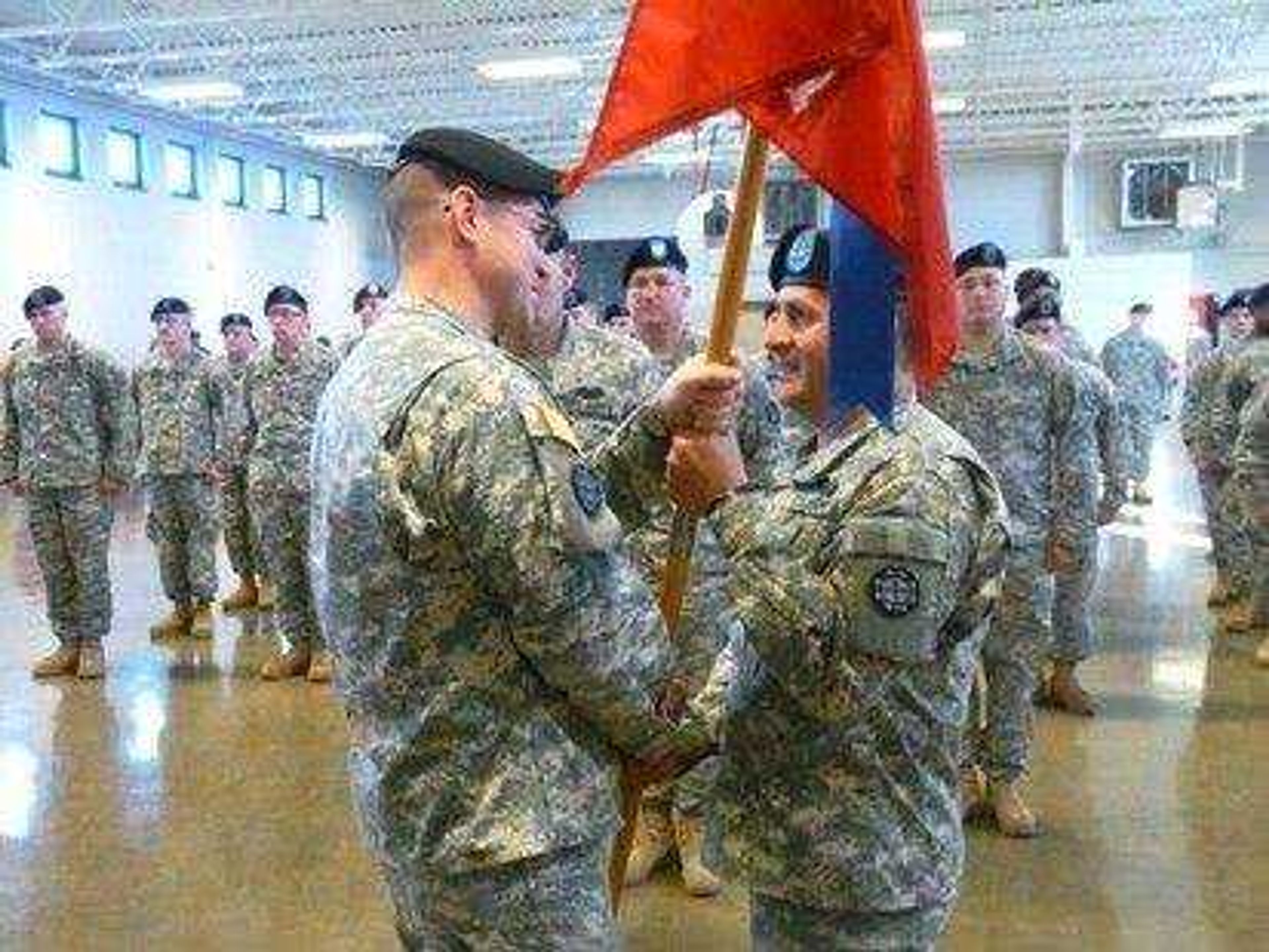 During the change of command ceremony, the unit guidon, or flag, was passed from Lt. Col. John Oberkirschto (left) to Capt. Juan Valencia (right) to symbolize the transfer of authority and responsibility.