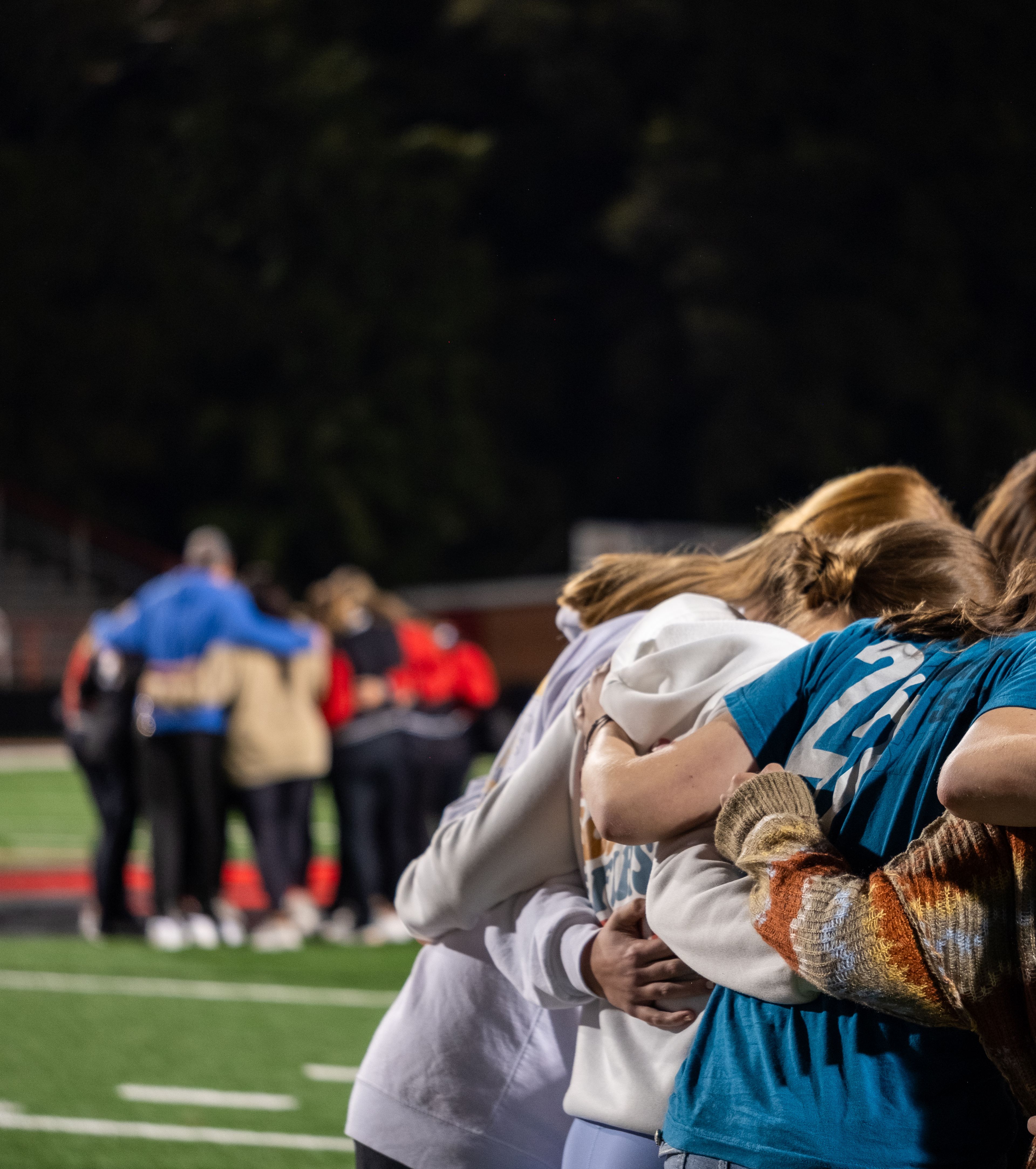 Participants pray in separate huddles, united by a shared faith.