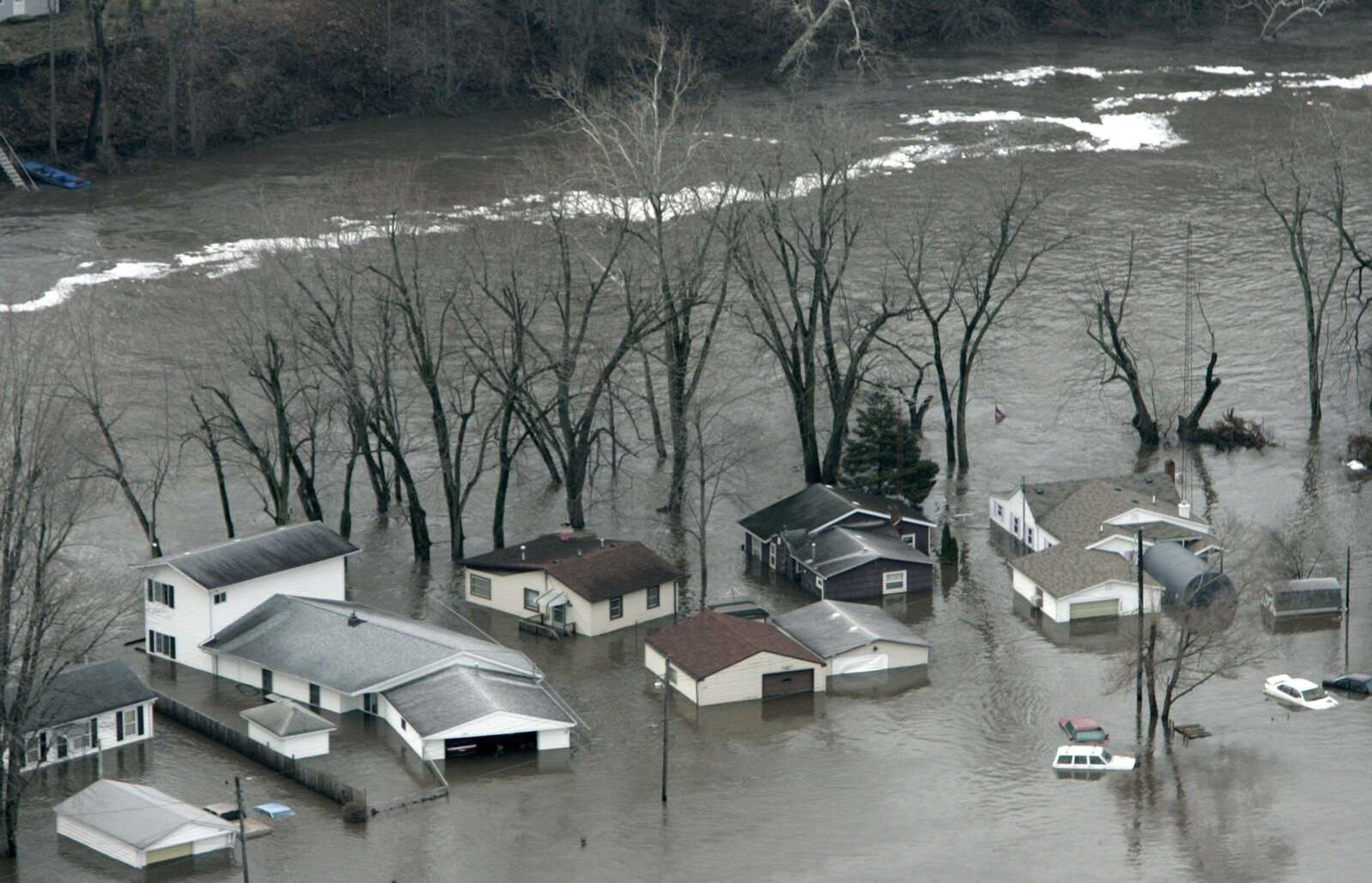 A group of homes were surrounded Wednesday by floodwater from the Tippecanoe River south of Monticello, Ind. Floodwaters began a slow withdrawal across a swath of northern Indiana, where surging rivers and streams killed three people and damaged hundreds of homes. (Michael Conroy ~ Associated Press)