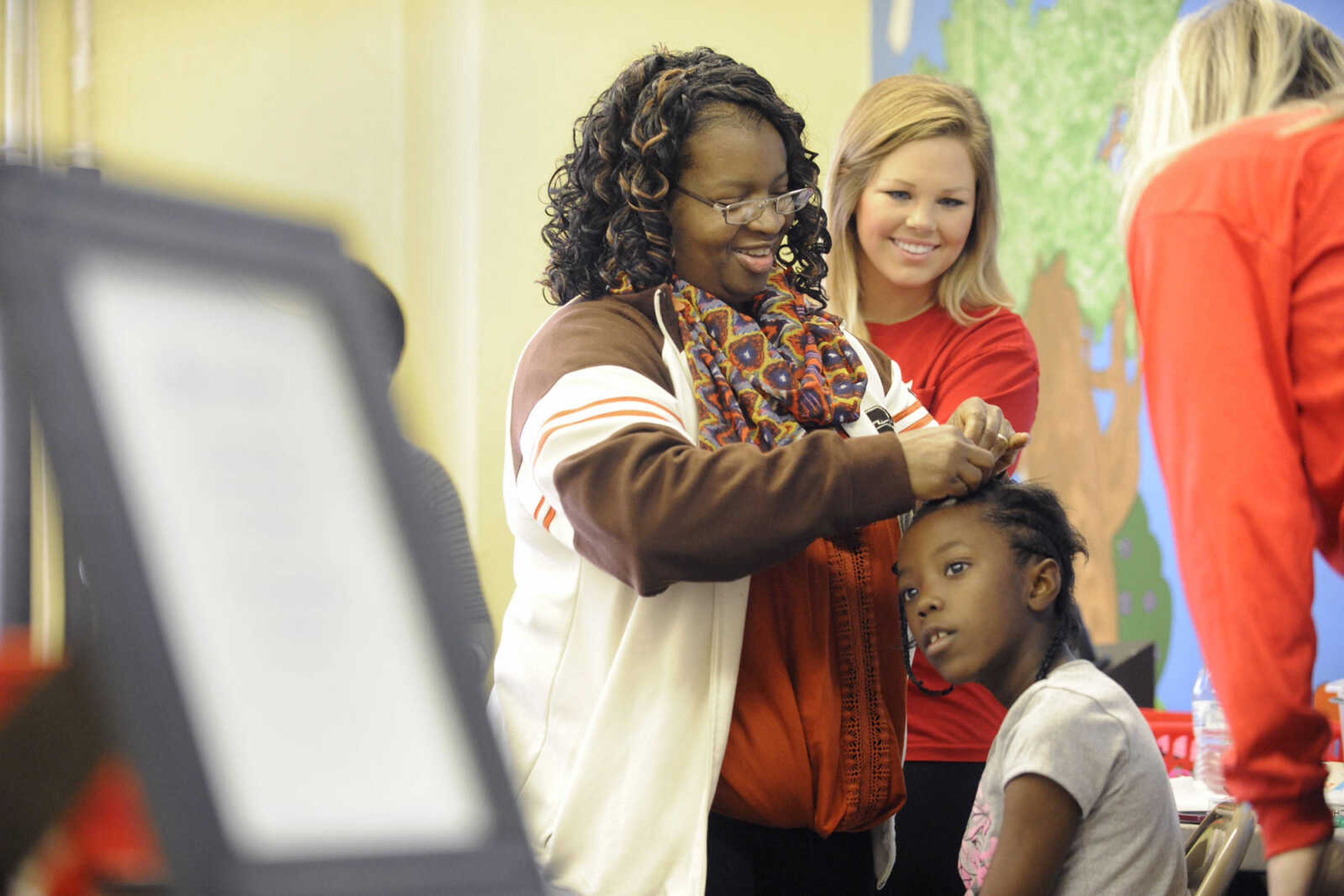 GLENN LANDBERG ~ glandberg@semissourian.com

Jalaya Parker has her hair french braided by Melissa Taylor during the fifth annual Help-Portrait event Saturday, Dec. 6, 2014 at the House of Hope in Cape Girardeau.